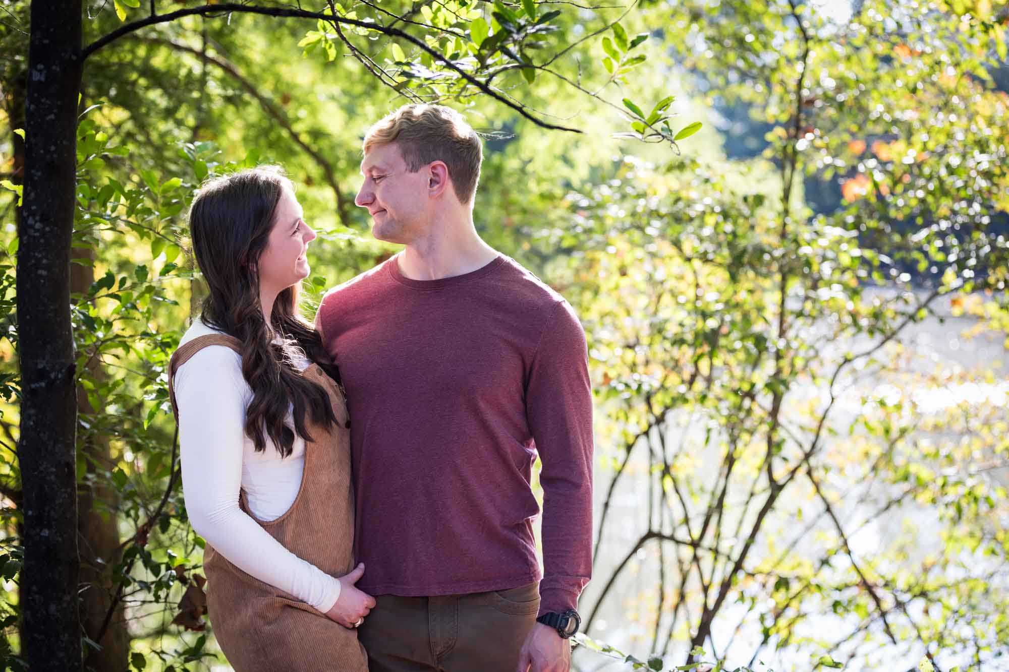 San Antonio Botanical Gardens family portrait of man wearing maroon shirt looking at woman wearing corduroy dress in the forest