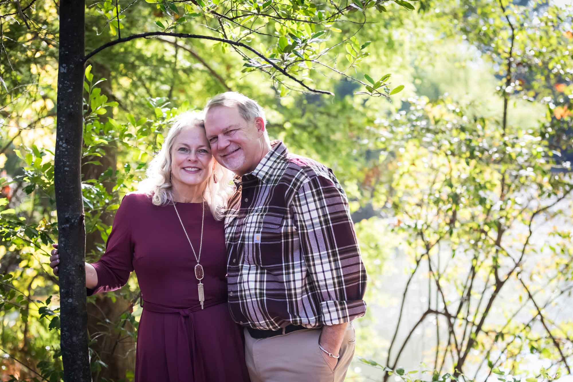 San Antonio Botanical Gardens family portrait of older woman wearing maroon dress standing with older man wearing plaid shirt in the forest
