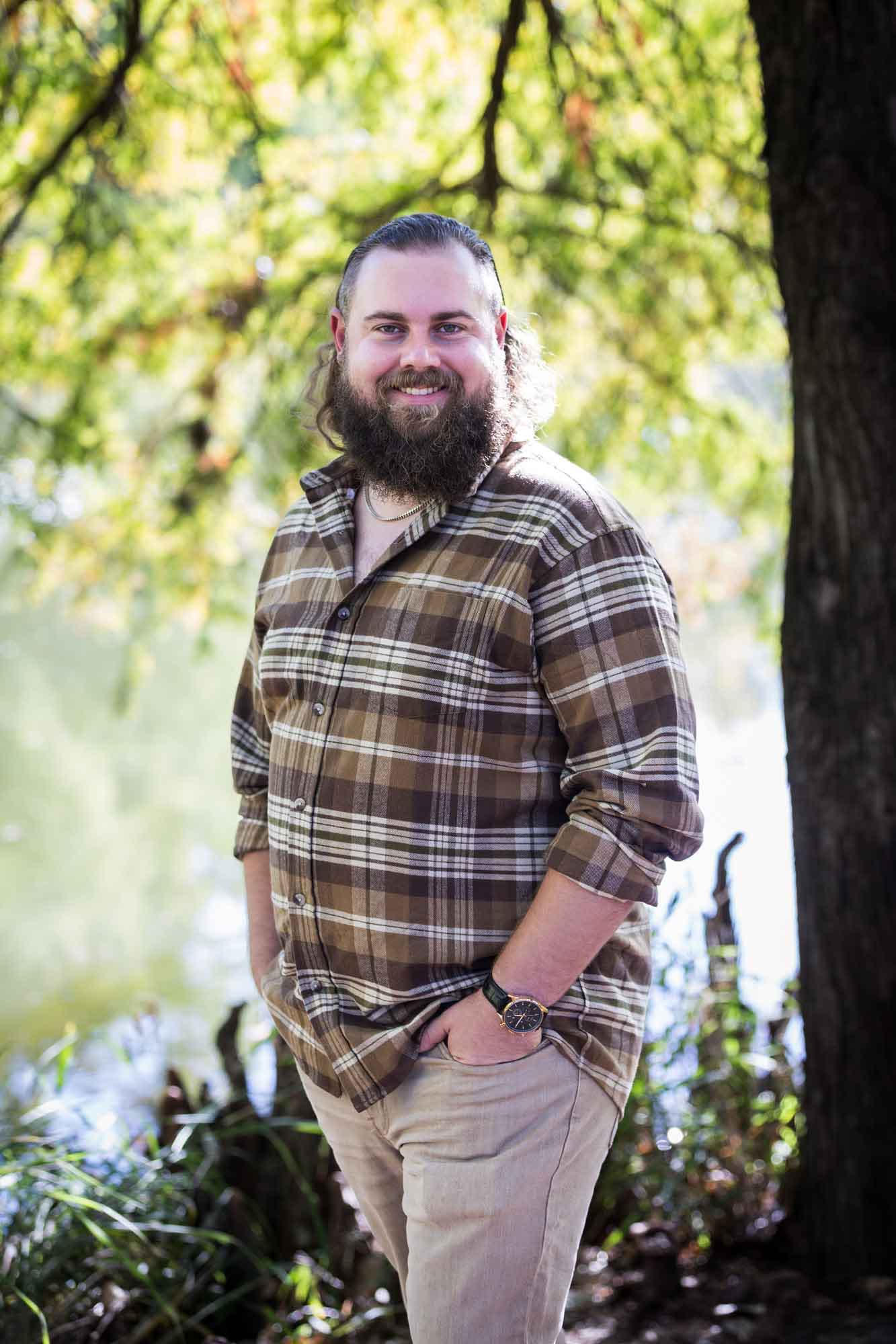 San Antonio Botanical Gardens family portrait of man with beard wearing brown plaid shirt standing in front of trees