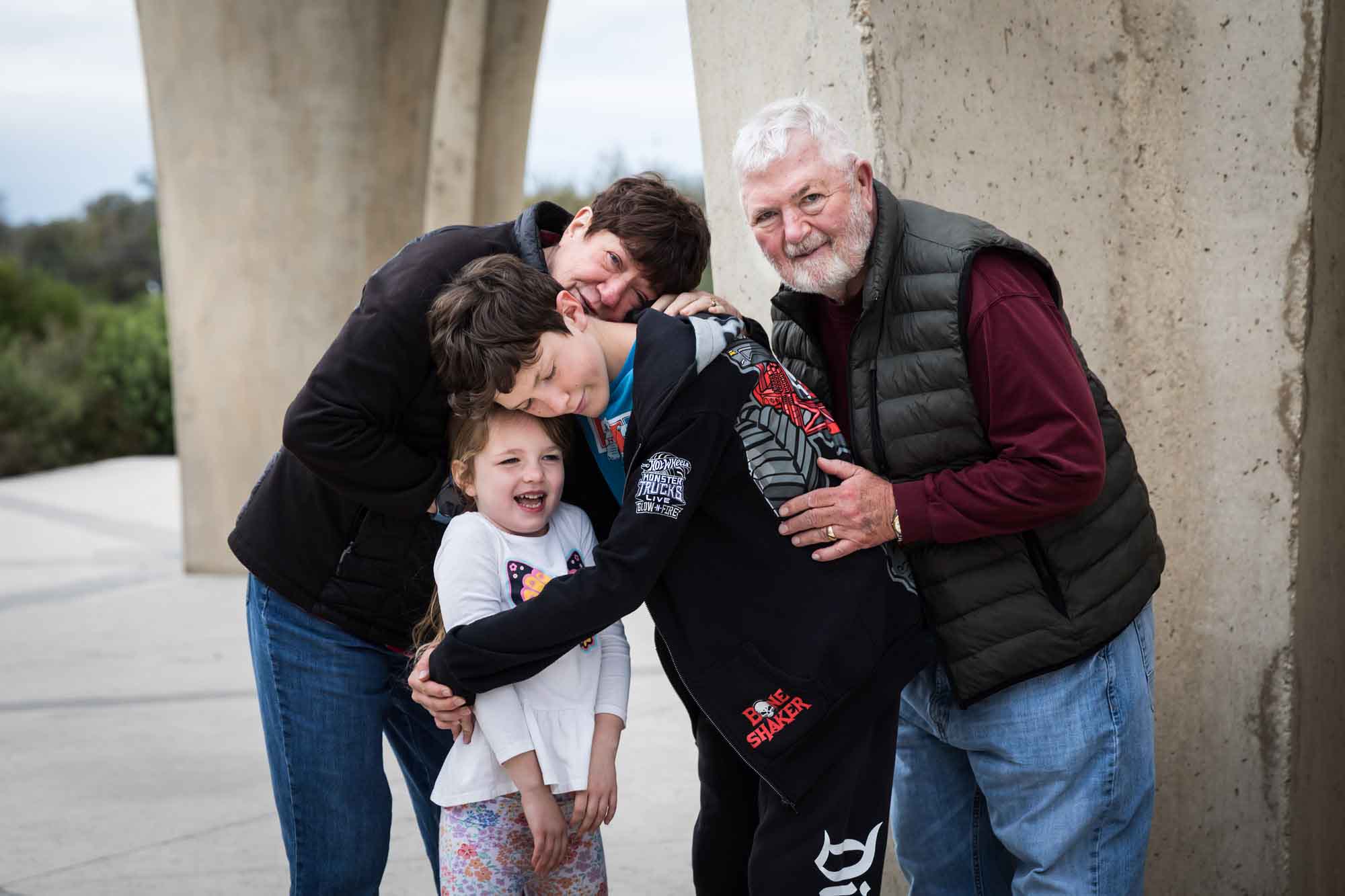 Grandparents hugging little girl and older boy during a Confluence Park family portrait session