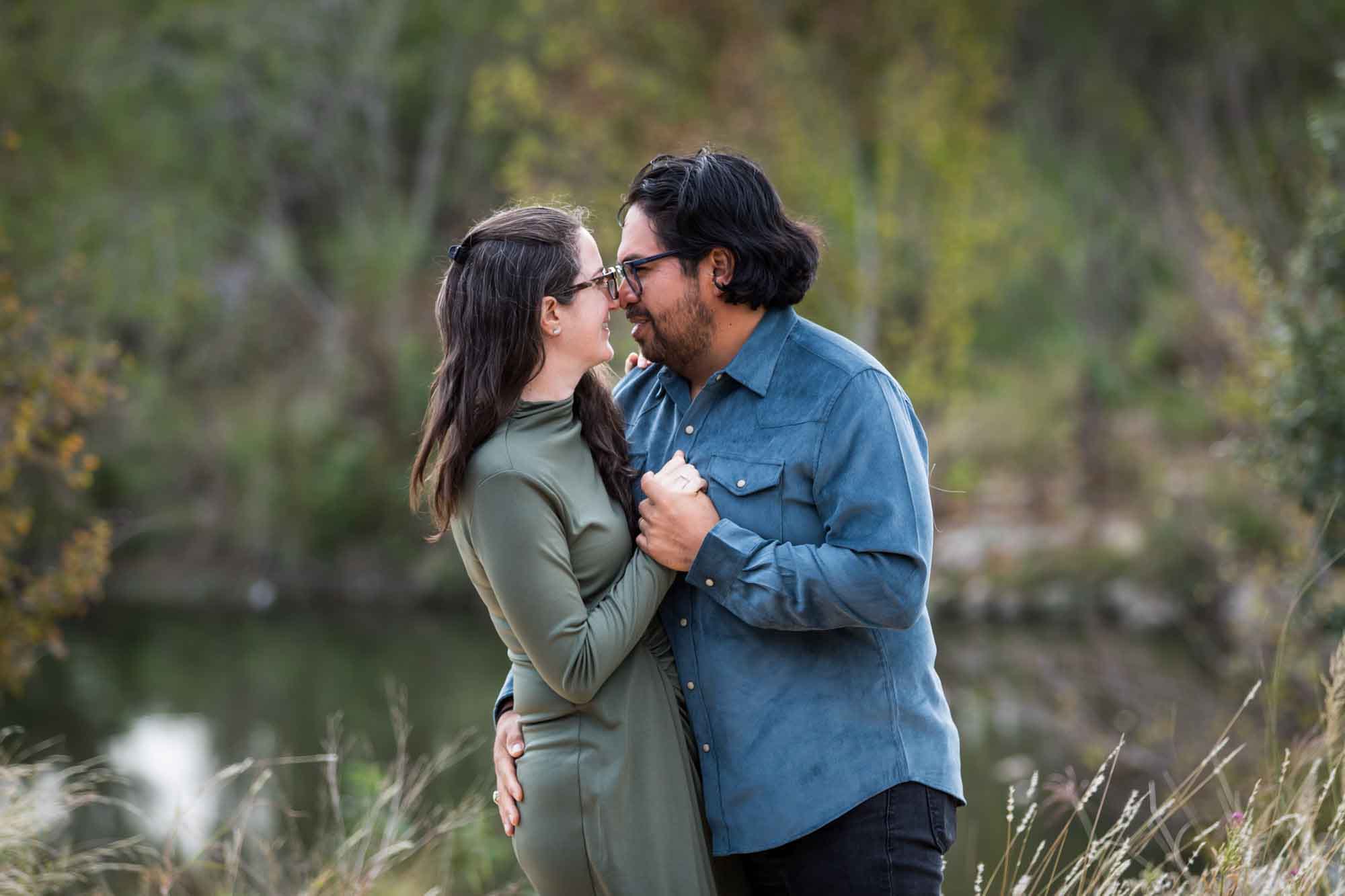 Man wearing denim long-sleeved shirt dancing with woman wearing green dress during a Confluence Park family portrait session