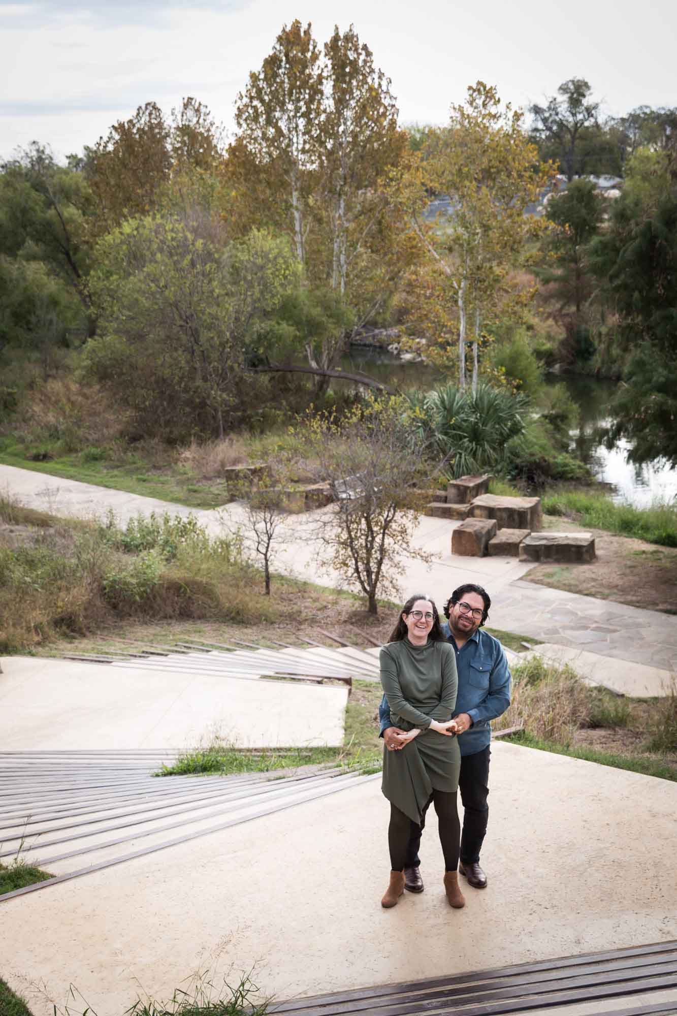 Man wearing denim long-sleeved shirt being dancing with a woman wearing green long-sleeved shirt on a staircase during a Confluence Park family portrait session