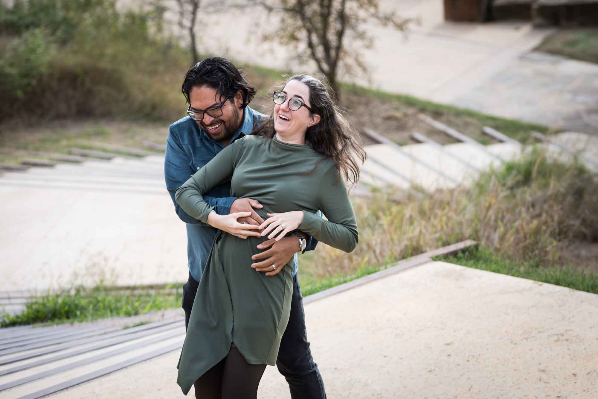Man wearing denim long-sleeved shirt being dancing with a woman wearing green long-sleeved dress during a Confluence Park family portrait session