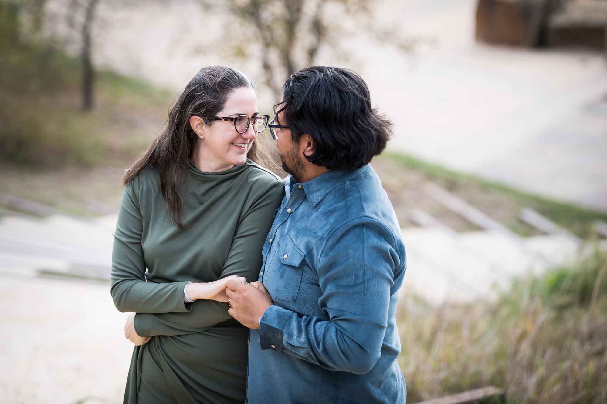 Man wearing denim long-sleeved shirt being dancing with a woman wearing green long-sleeved dress during a Confluence Park family portrait session