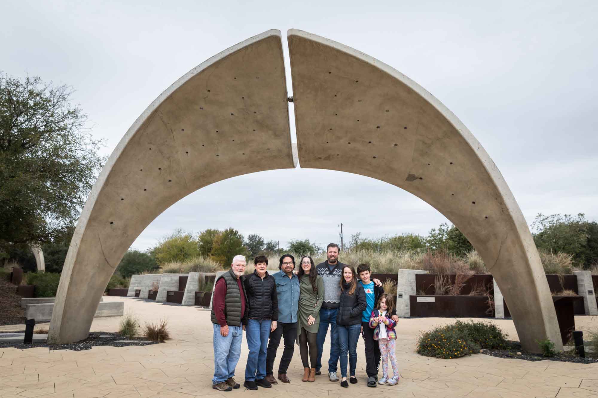 Family of eight people standing together under concrete arch during a Confluence Park family portrait session