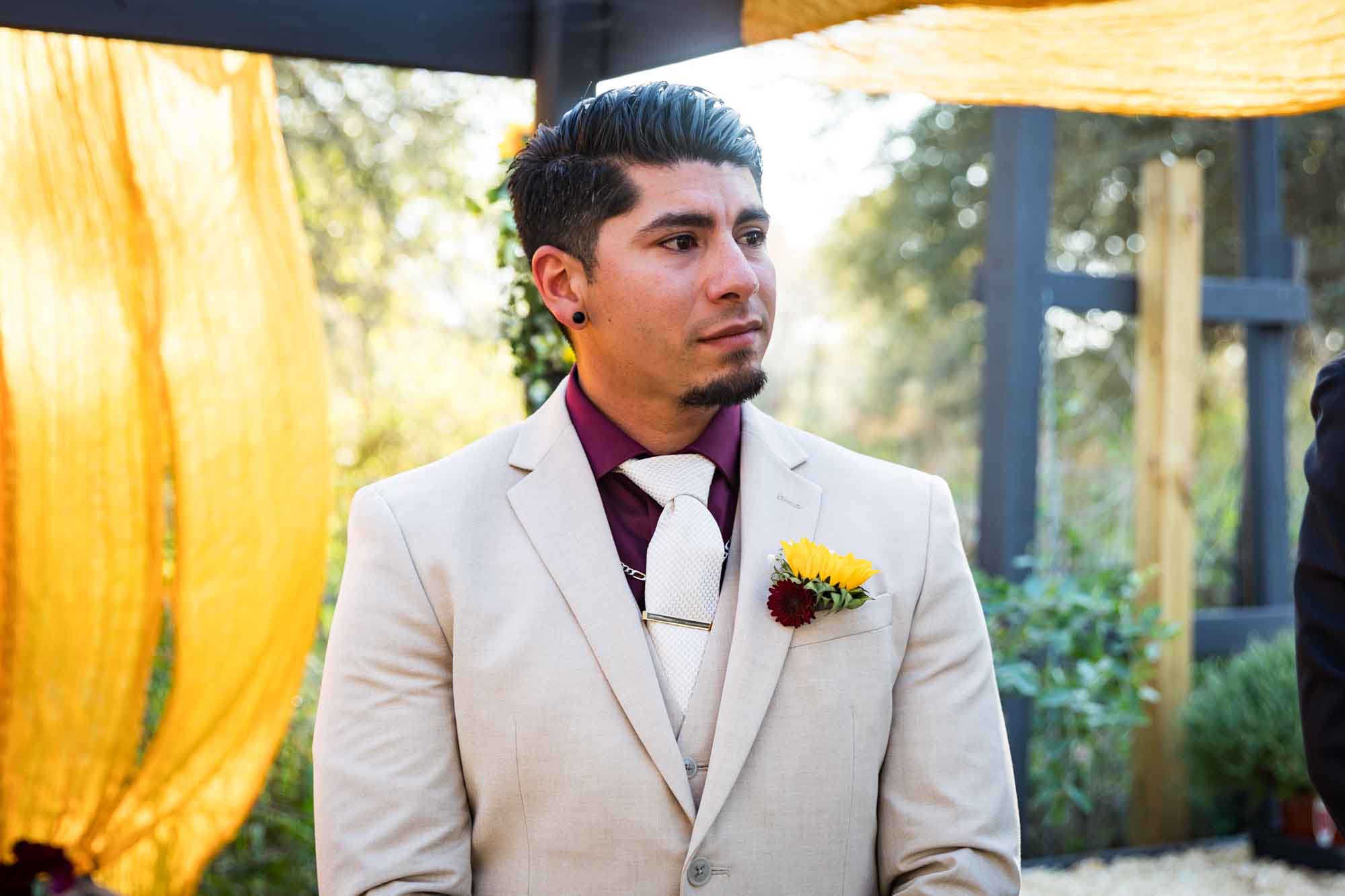 Groom wearing tan suit about to cry during ceremony at a San Antonio DIY wedding