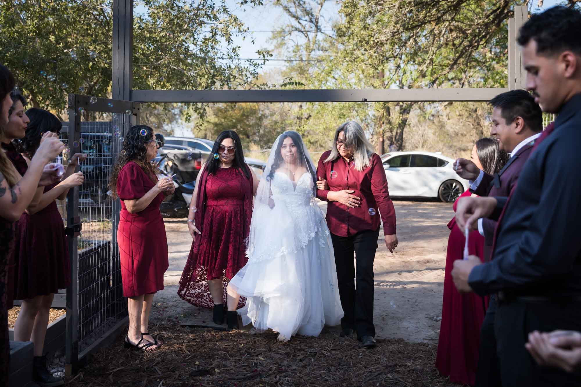 Bride and bridesmaids walking down aisle during ceremony at a San Antonio DIY wedding