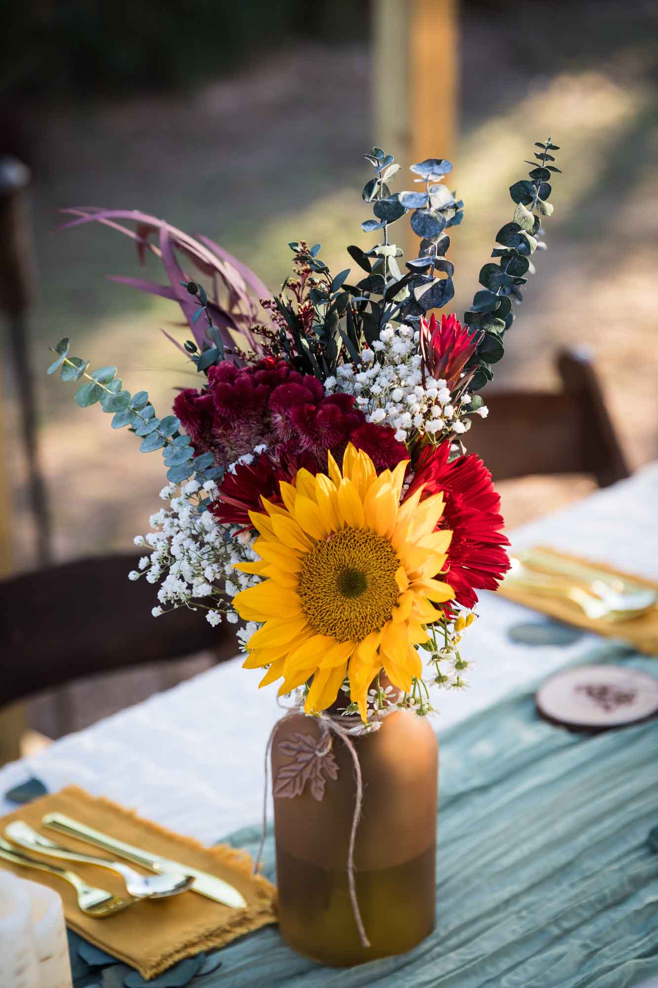 Brown glass vase holding multicolored flowers on a table at a San Antonio DIY wedding