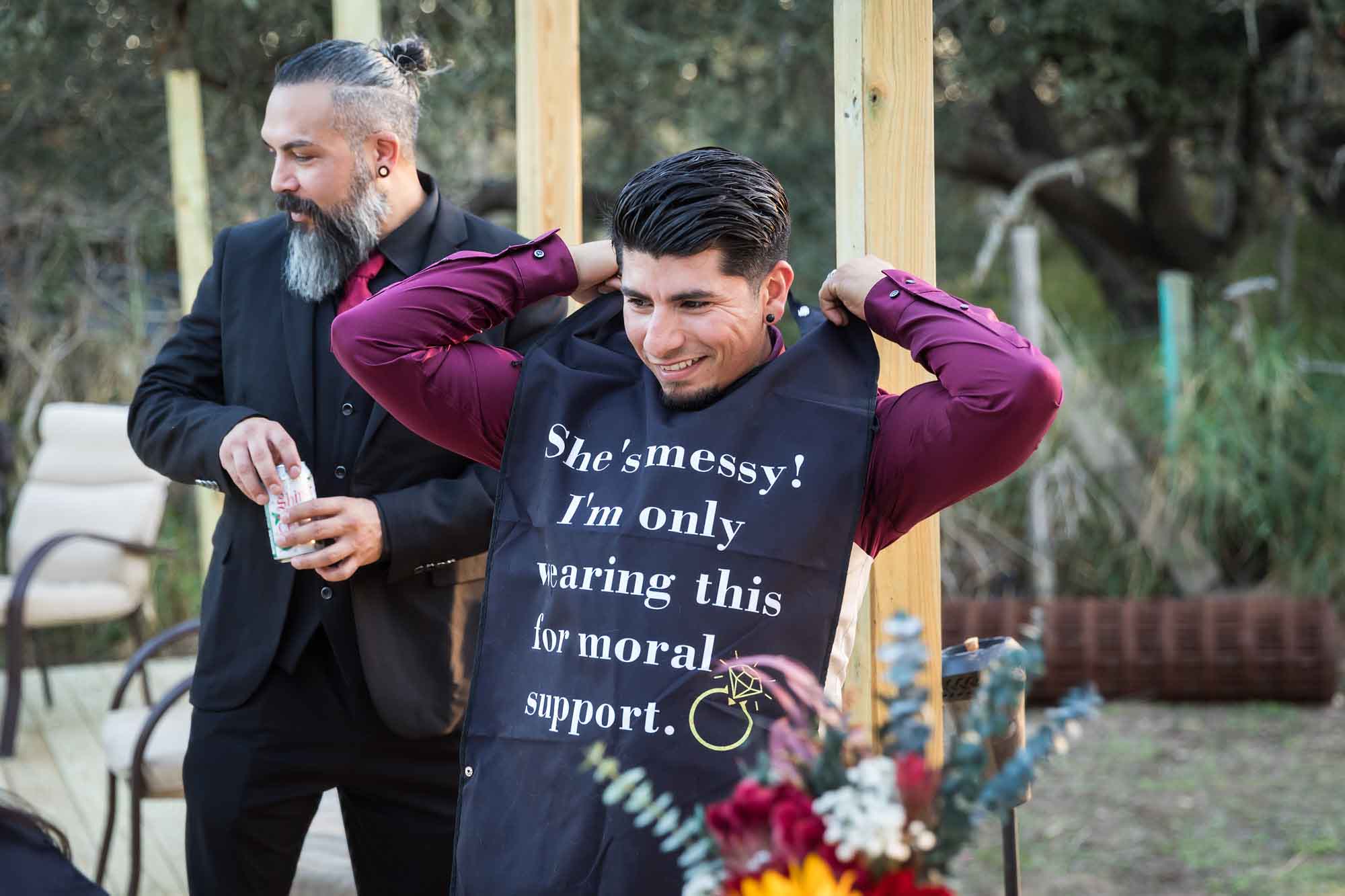Groom putting on black bib during reception at a San Antonio DIY wedding