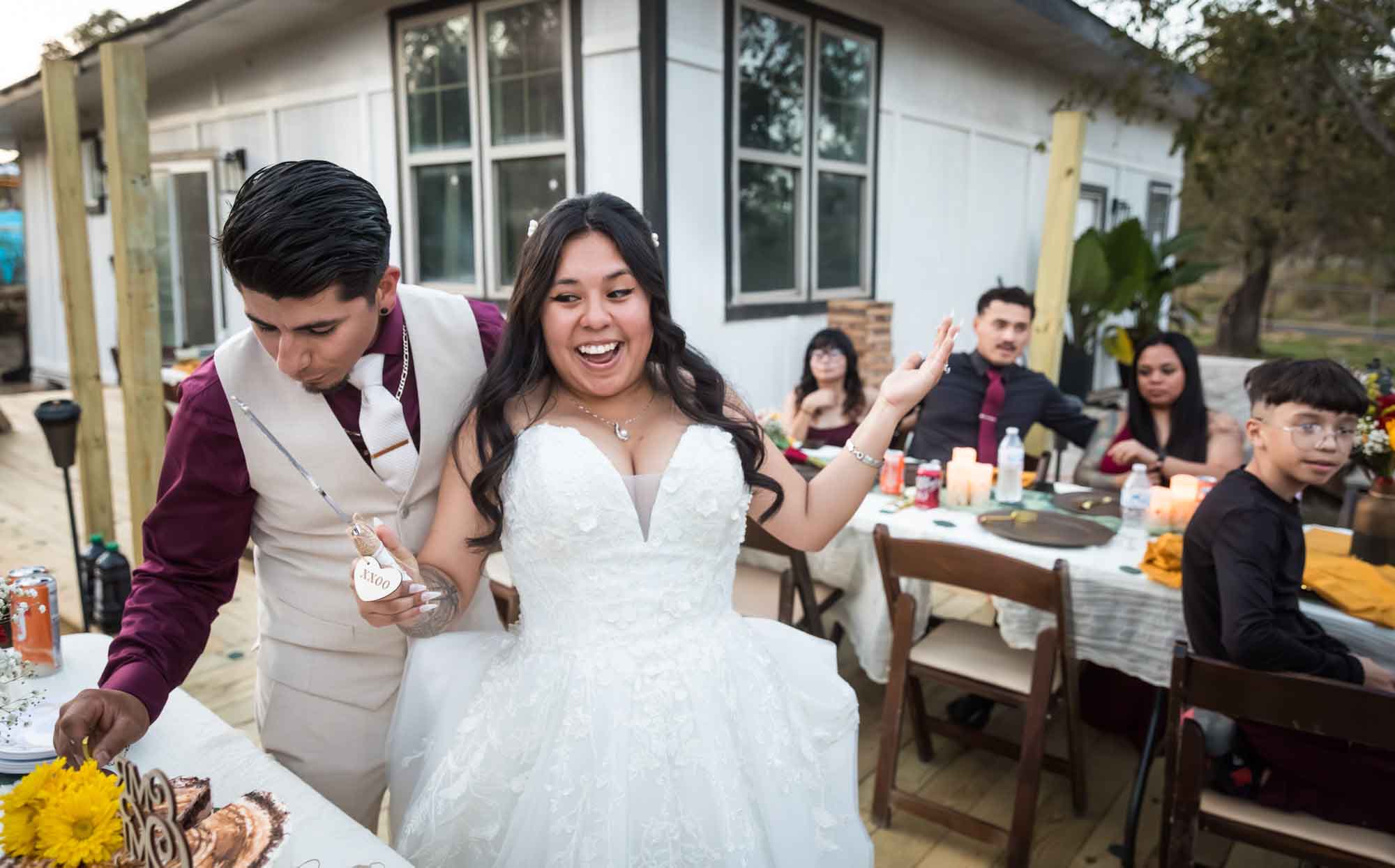 Bride and groom holding cake knife after cutting wedding cake at a San Antonio DIY wedding