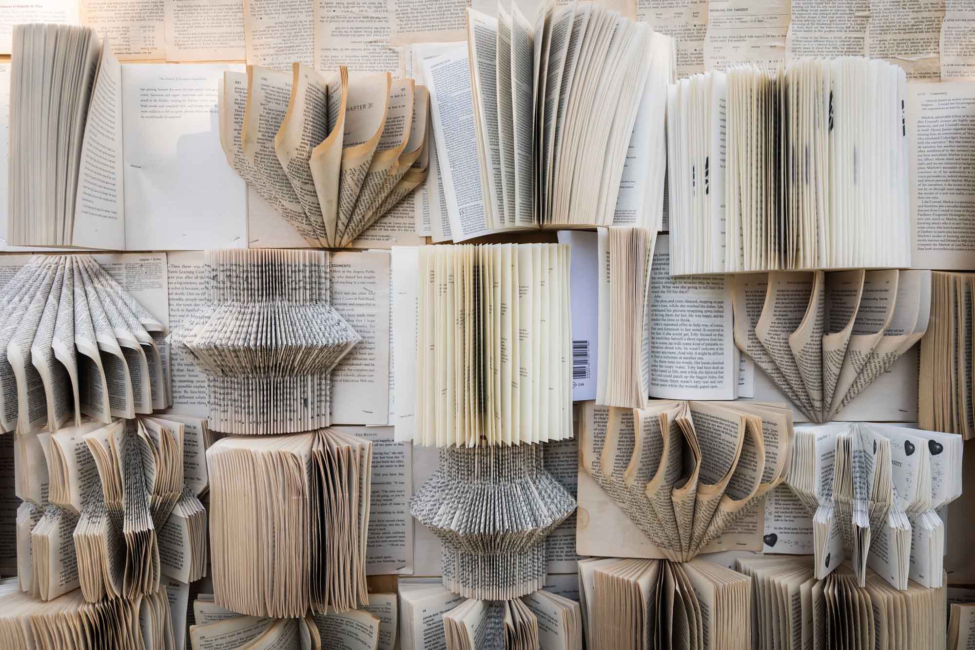 Book background with intricately folded open books at a San Antonio DIY wedding