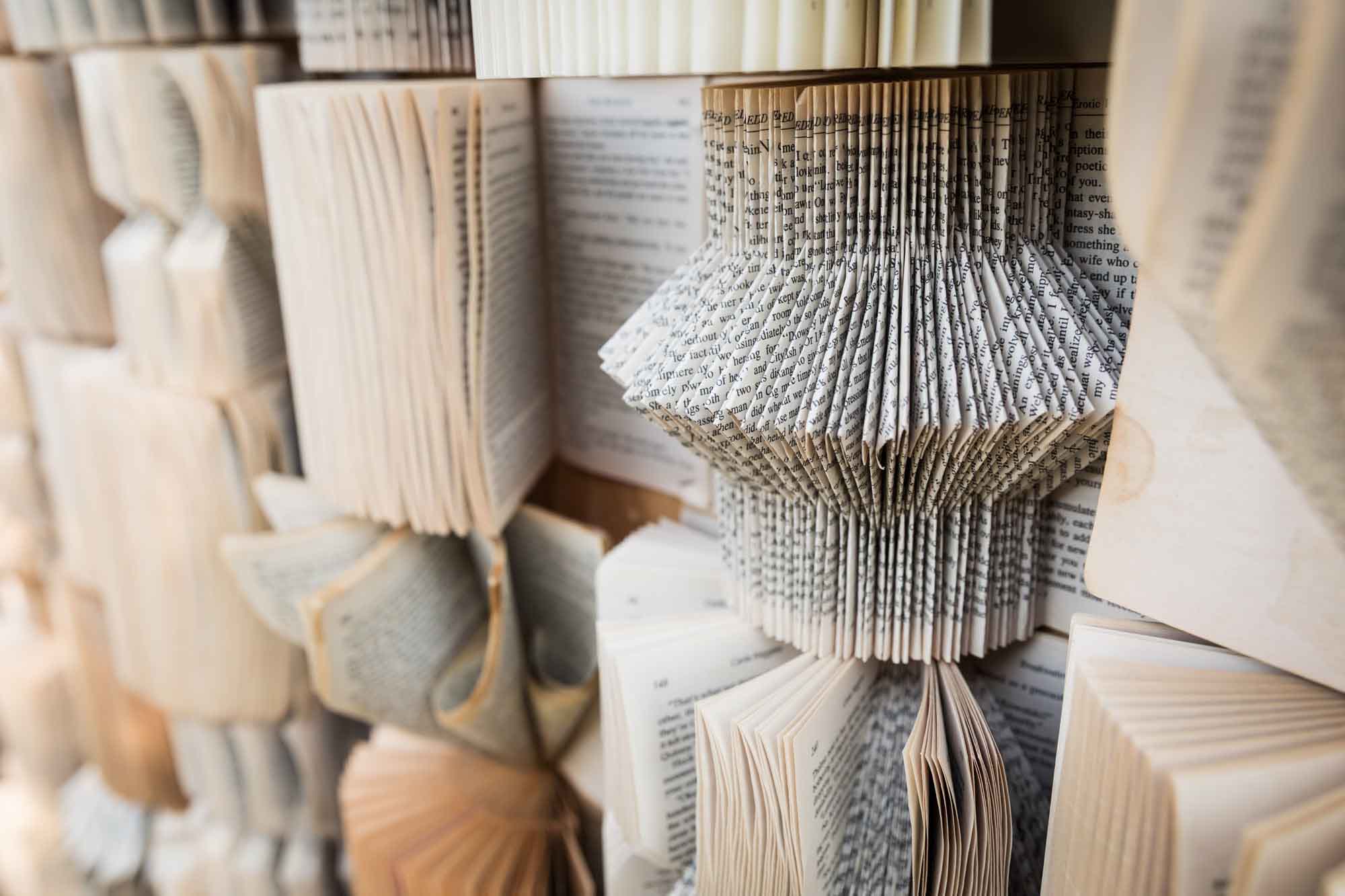Book background with intricately folded open books at a San Antonio DIY wedding