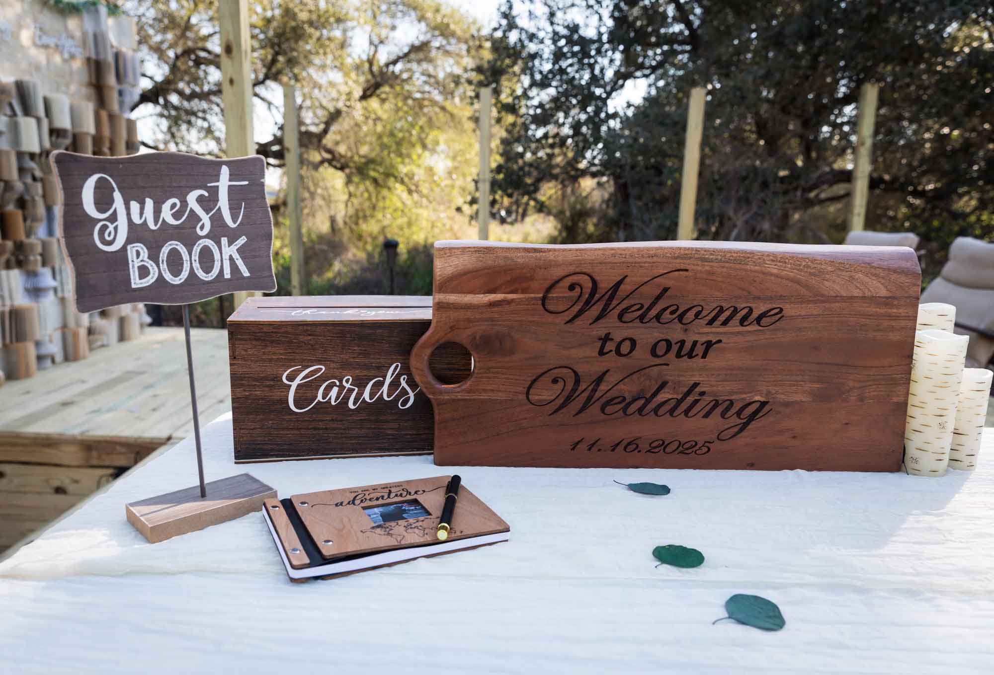 Table with wooden cutting board, card box, guest book, and guest book sign at a San Antonio DIY wedding