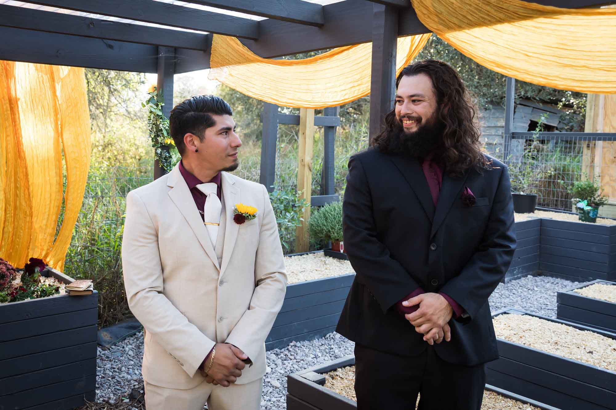Groom wearing tan suit smiling with best man wearing black suit at a San Antonio DIY wedding