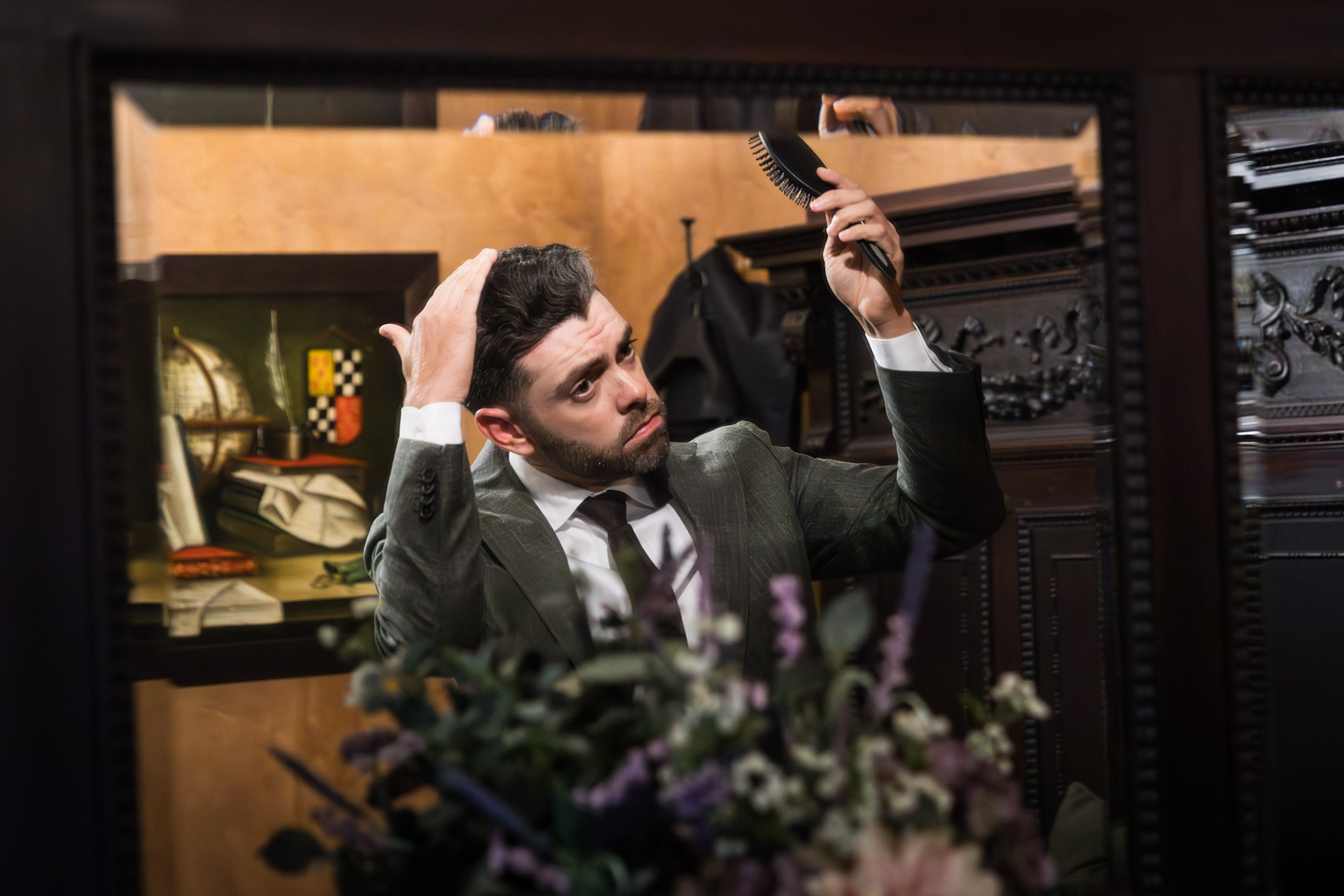 Groom checking his hair in the mirror in groom's suite at a Chapel Dulcinea wedding