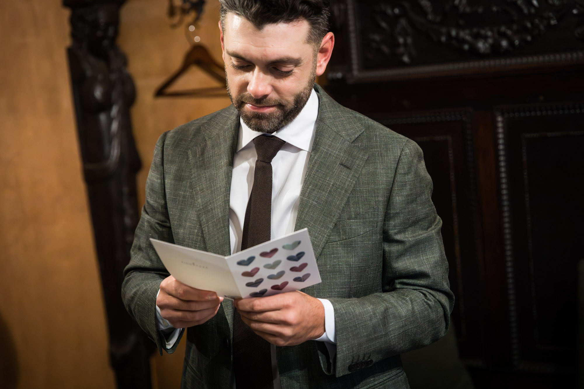Groom wearing grey jacket wearing card from bride at a Chapel Dulcinea wedding