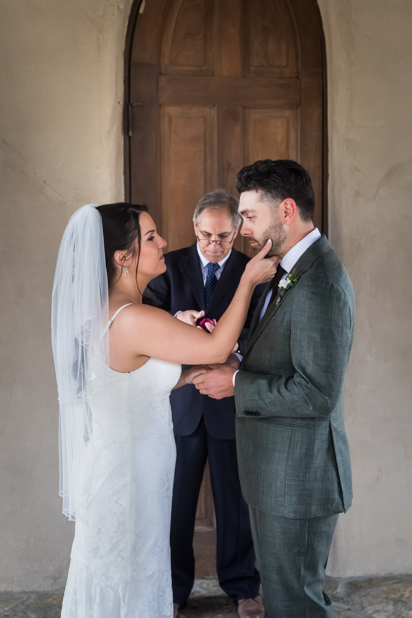 Bride brushing away tear from groom's face during ceremony at a Chapel Dulcinea wedding