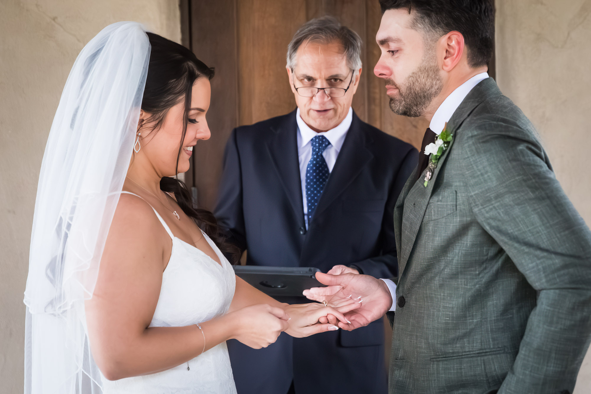 Bride putting ring on groom's finger during ceremony at a Chapel Dulcinea wedding