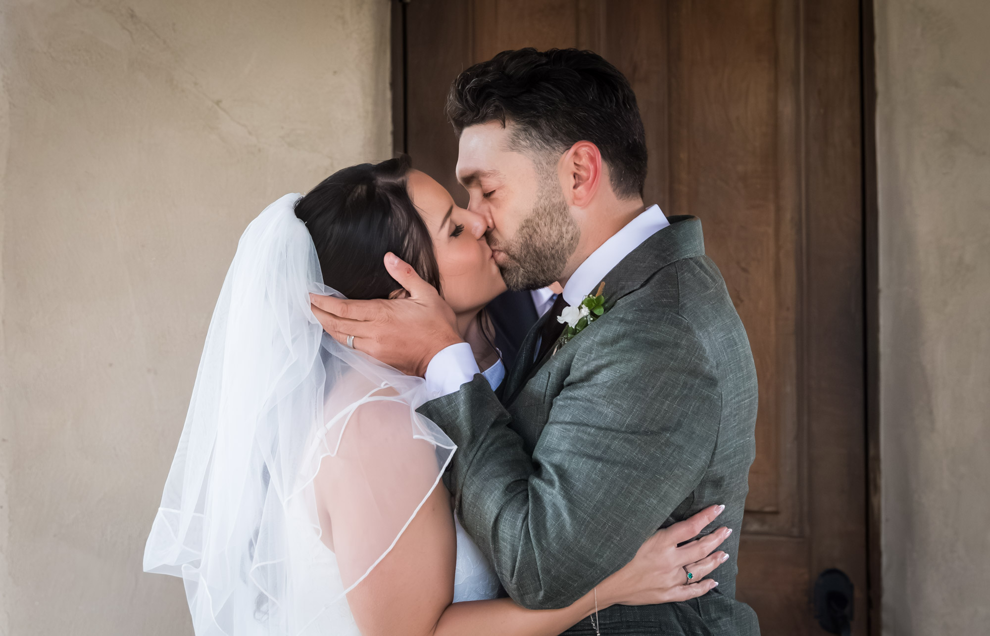 Bride wearing veil and groom kissing after ceremony at a Chapel Dulcinea wedding