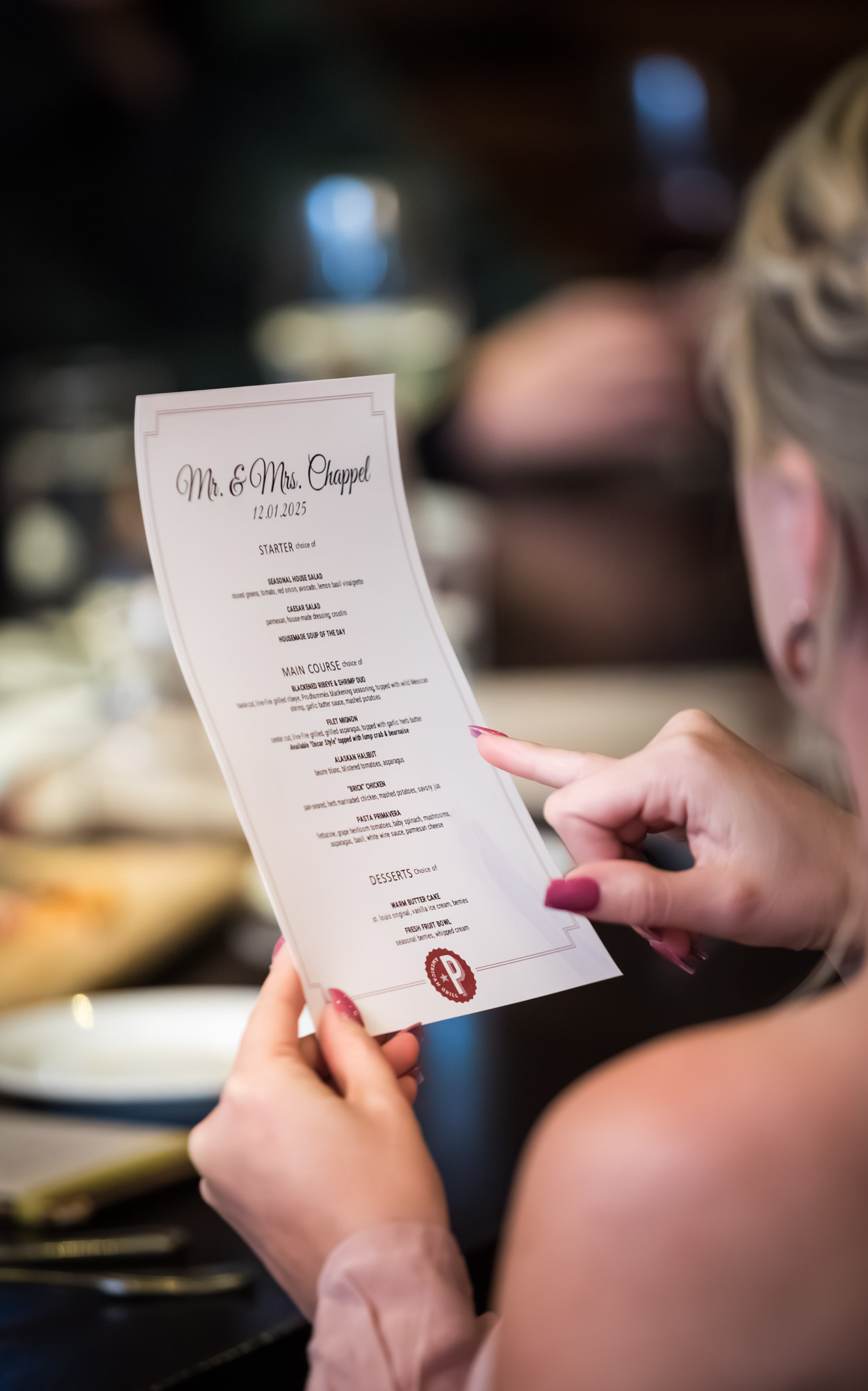 Close up of woman holding menu at a dinner table during wedding reception