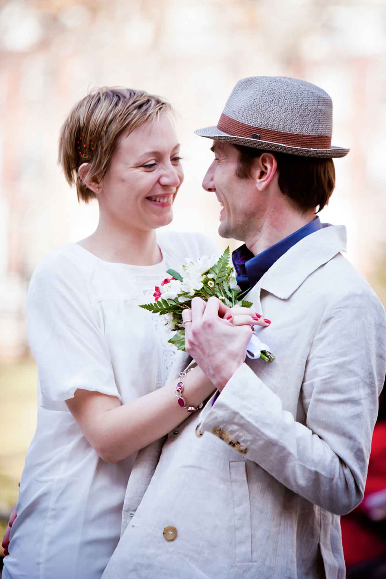 Bride with short hair dancing with groom wearing hat for article on how to elope in San Antonio