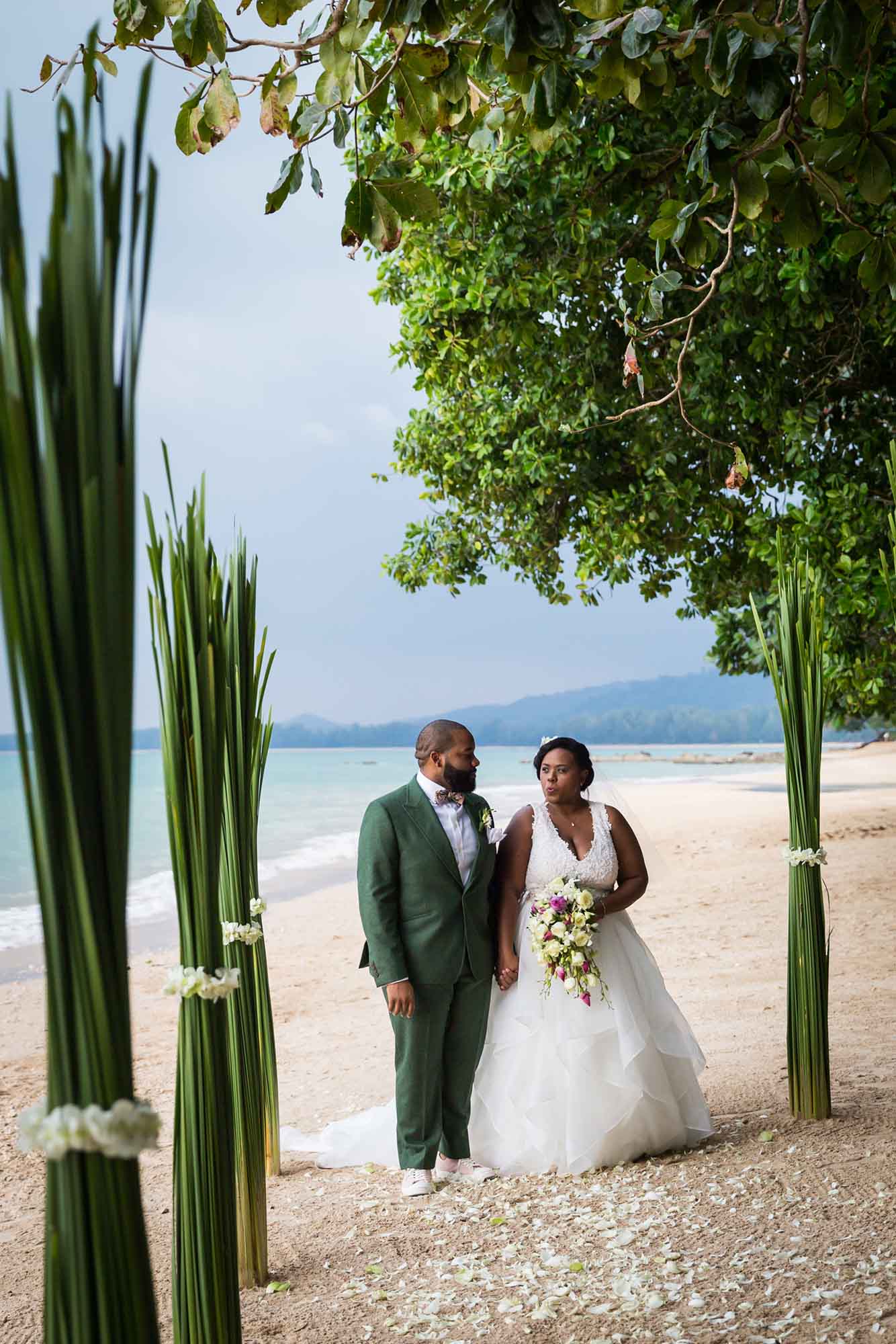 African American bride and groom holding hands and walking up beach in Thailand for article on how to elope in San Antonio