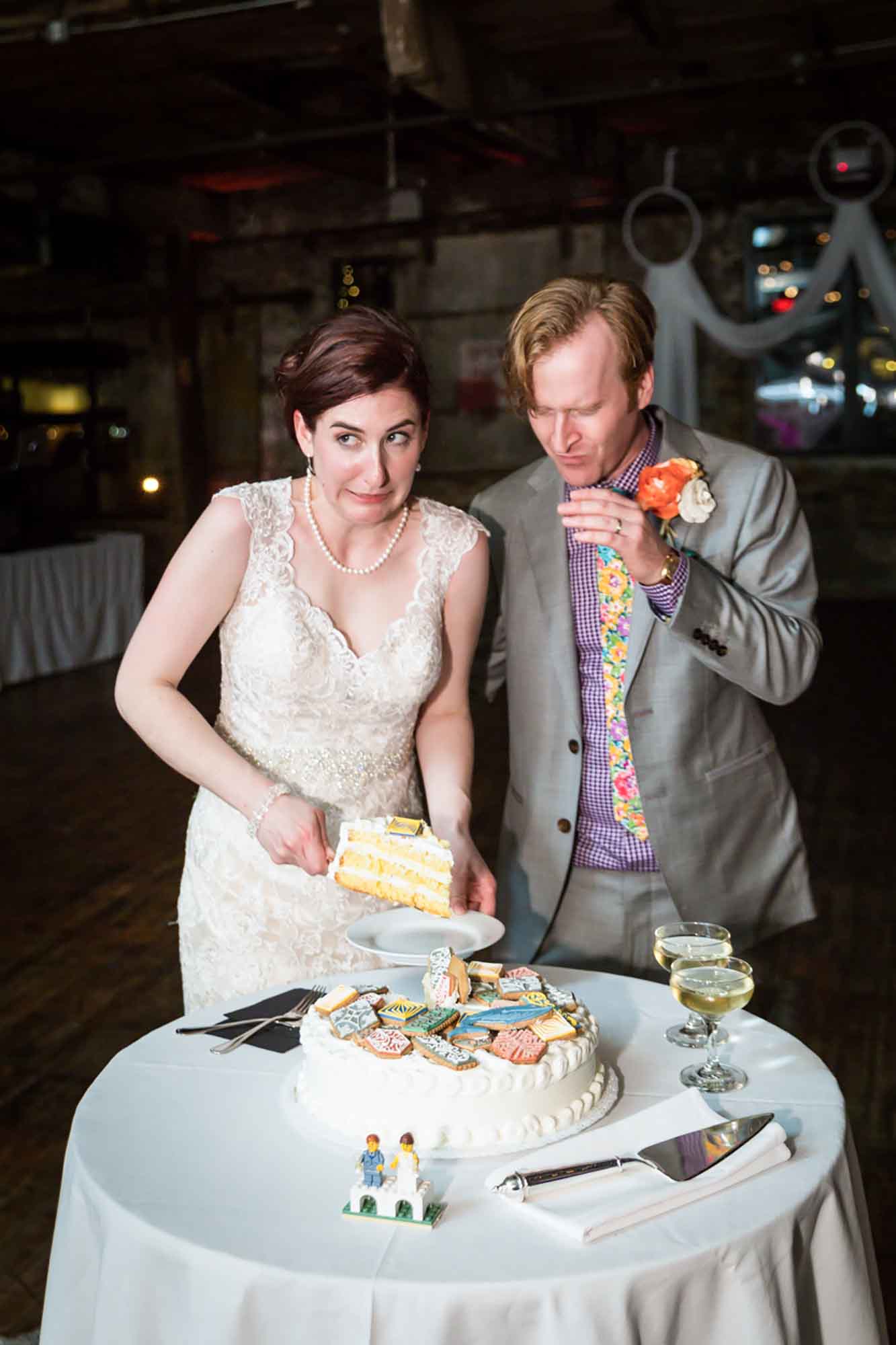 Bride cutting into wedding cake covered in colorful cookies with groom wearing grey suit for article on how to elope in San Antonio
