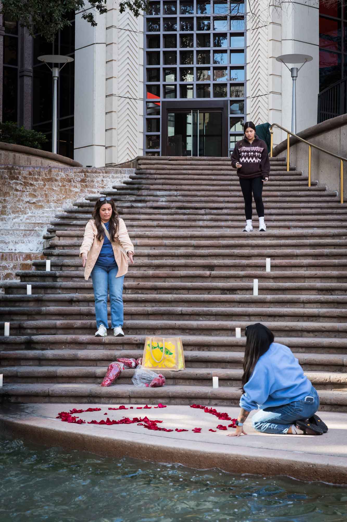 Three women preparing for a proposal on the steps of the Weston Centre