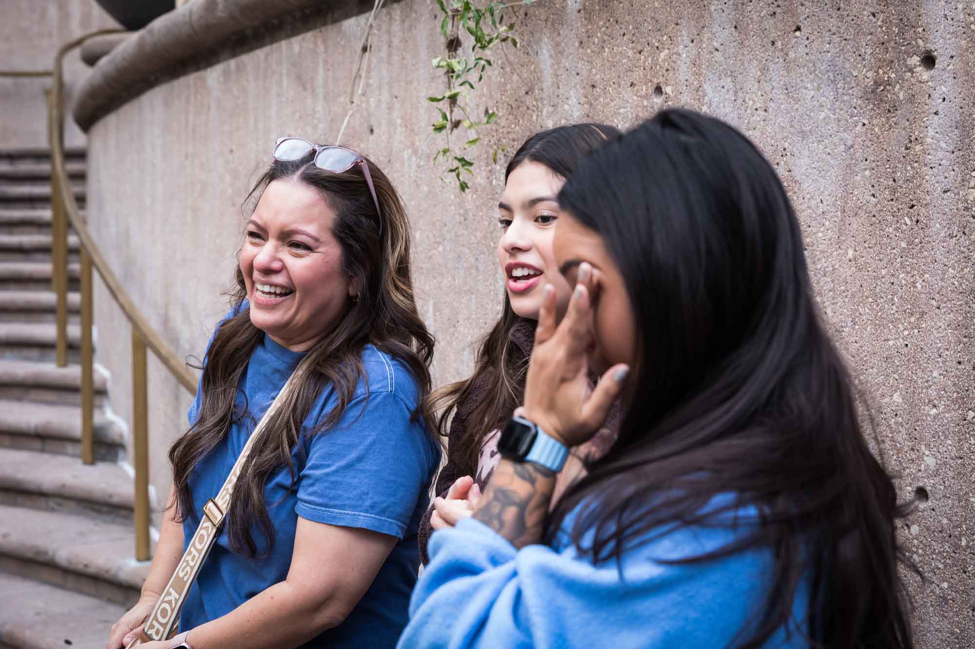 Three women laughing and drying during a downtown San Antonio surprise proposal