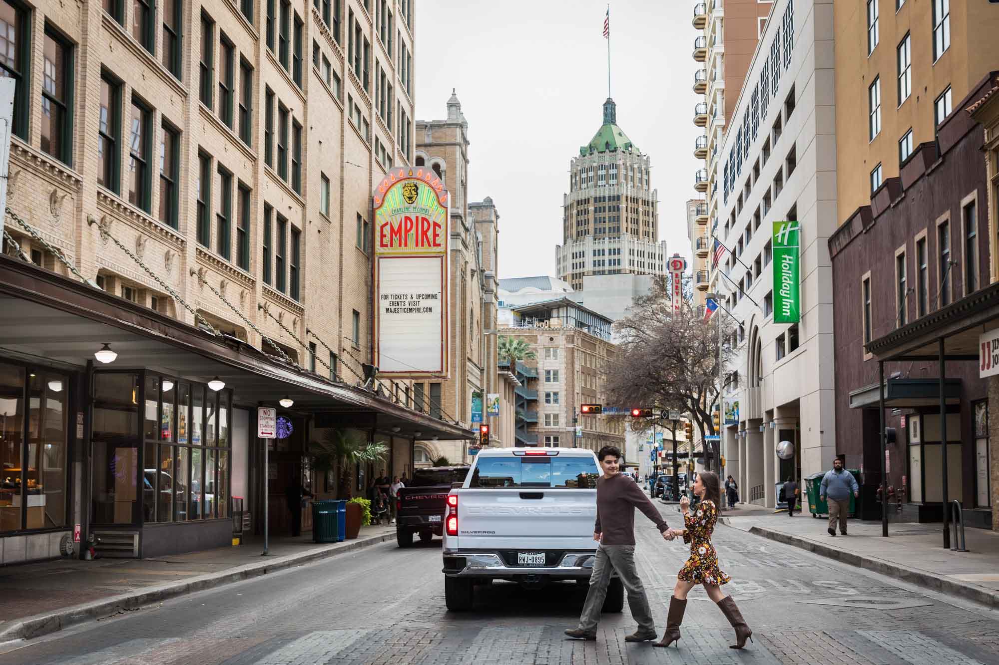 Couple holding hands and crossing busy street during a downtown San Antonio surprise proposal