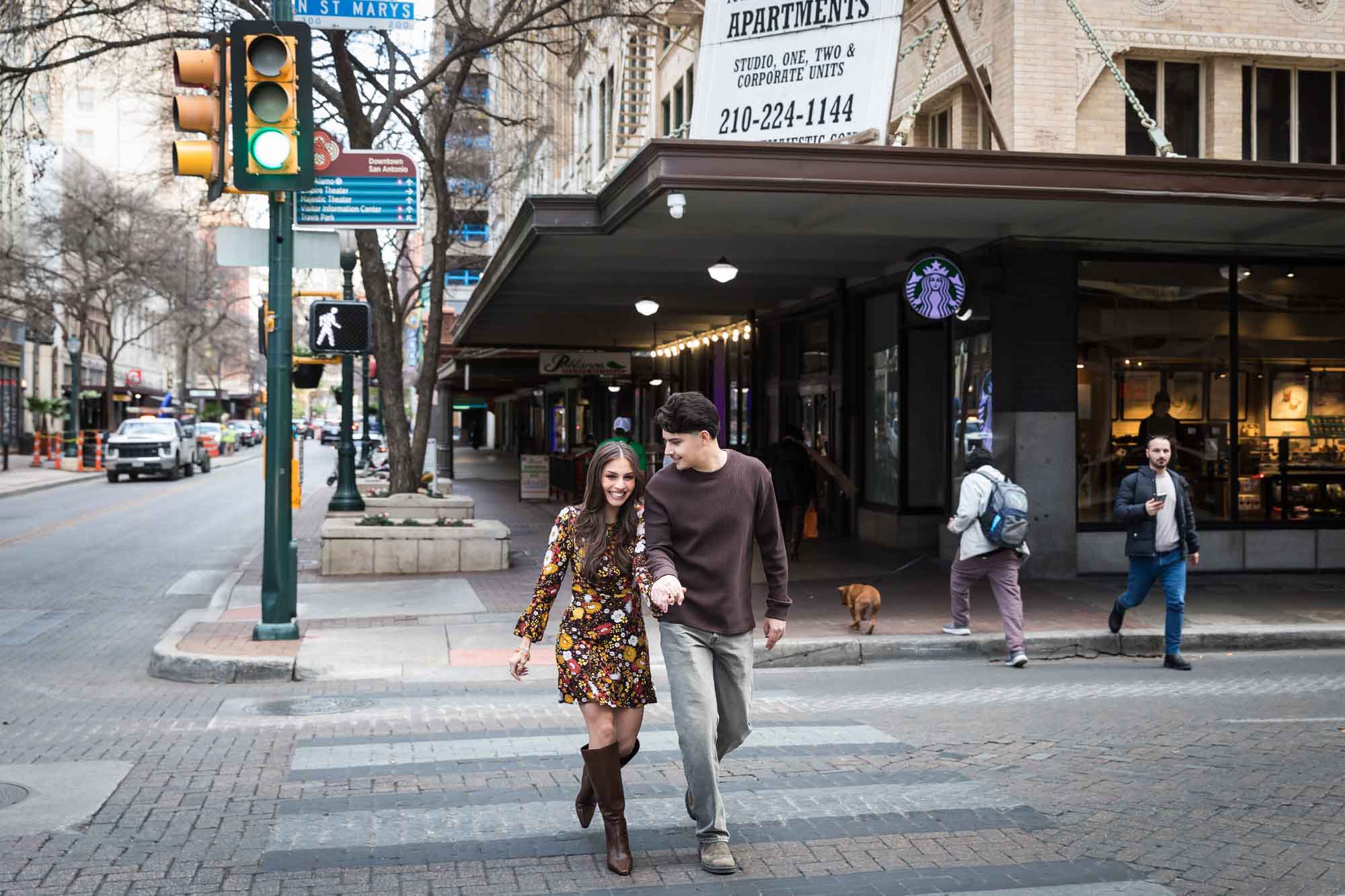 Couple holding hands and crossing busy street during a downtown San Antonio surprise proposal