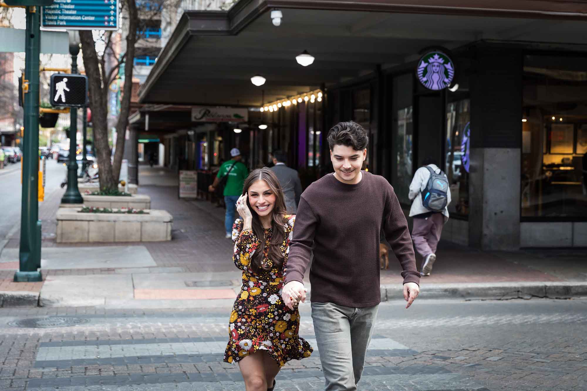 Couple holding hands and crossing busy street during a downtown San Antonio surprise proposal