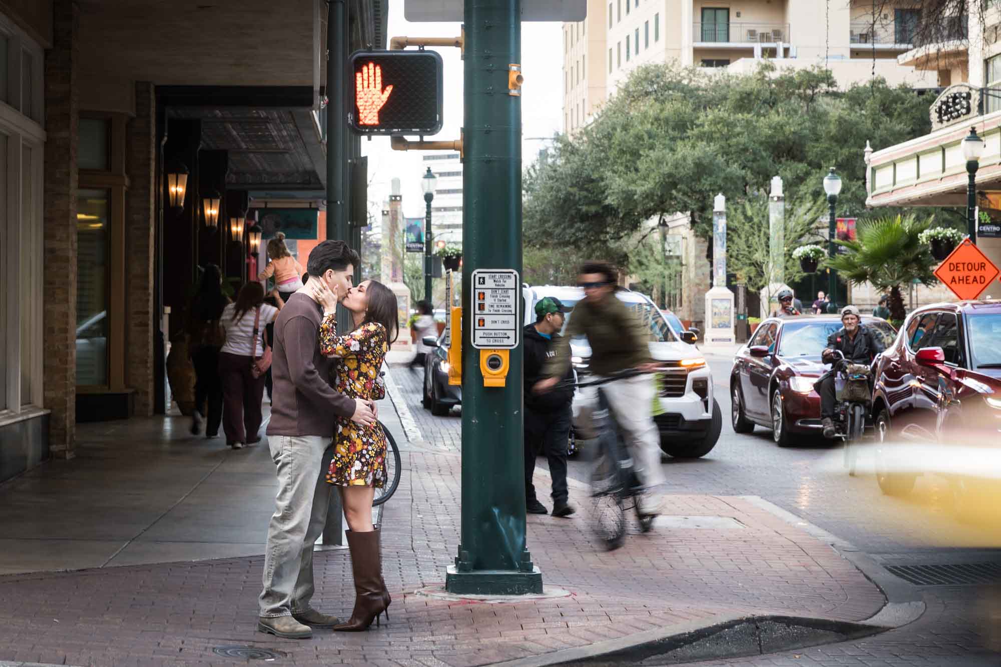 Couple kissing on busy street corner during a downtown San Antonio surprise proposal