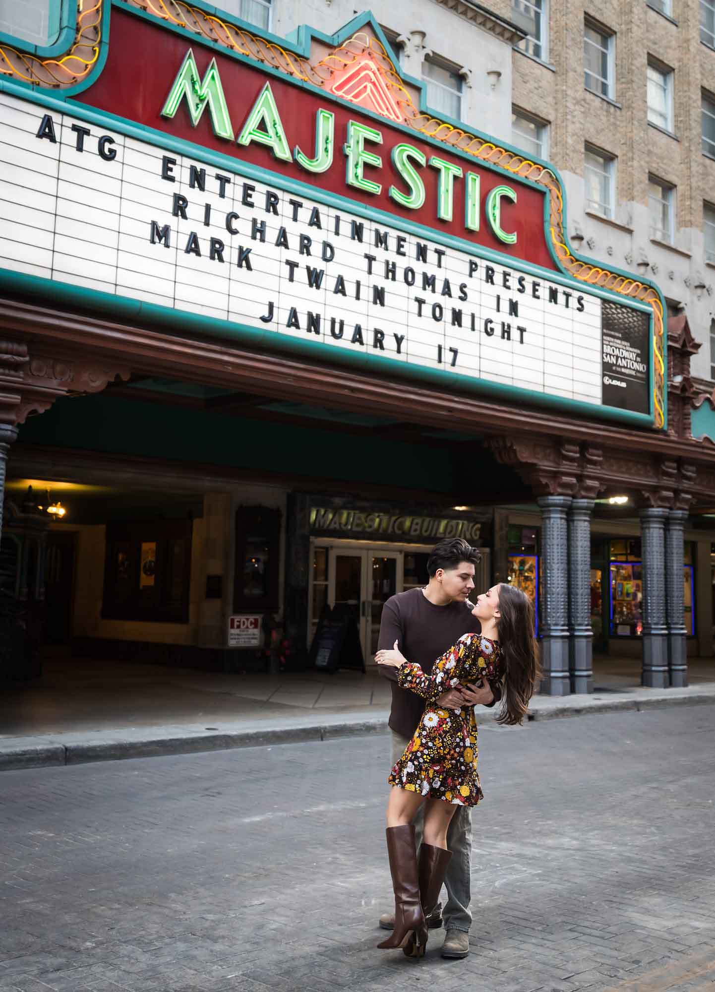 Couple dancing in front of Majestic Theatre marquee in street during a downtown San Antonio surprise proposal