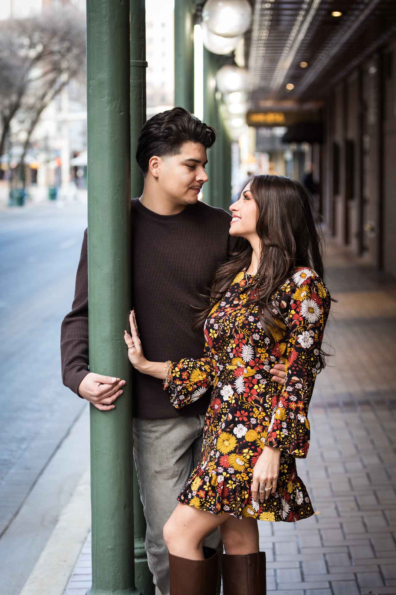Man and woman standing in front of green columns of Gunter Hotel during a downtown San Antonio surprise proposal