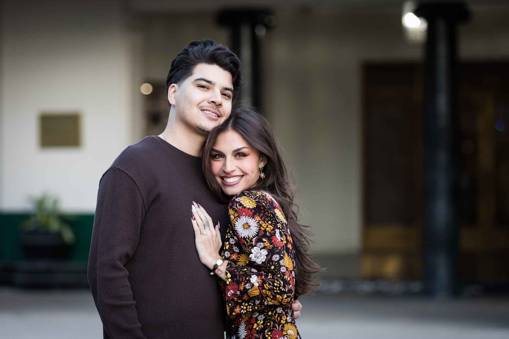 Man and woman hugging in front of Menger Hotel during a downtown San Antonio surprise proposal