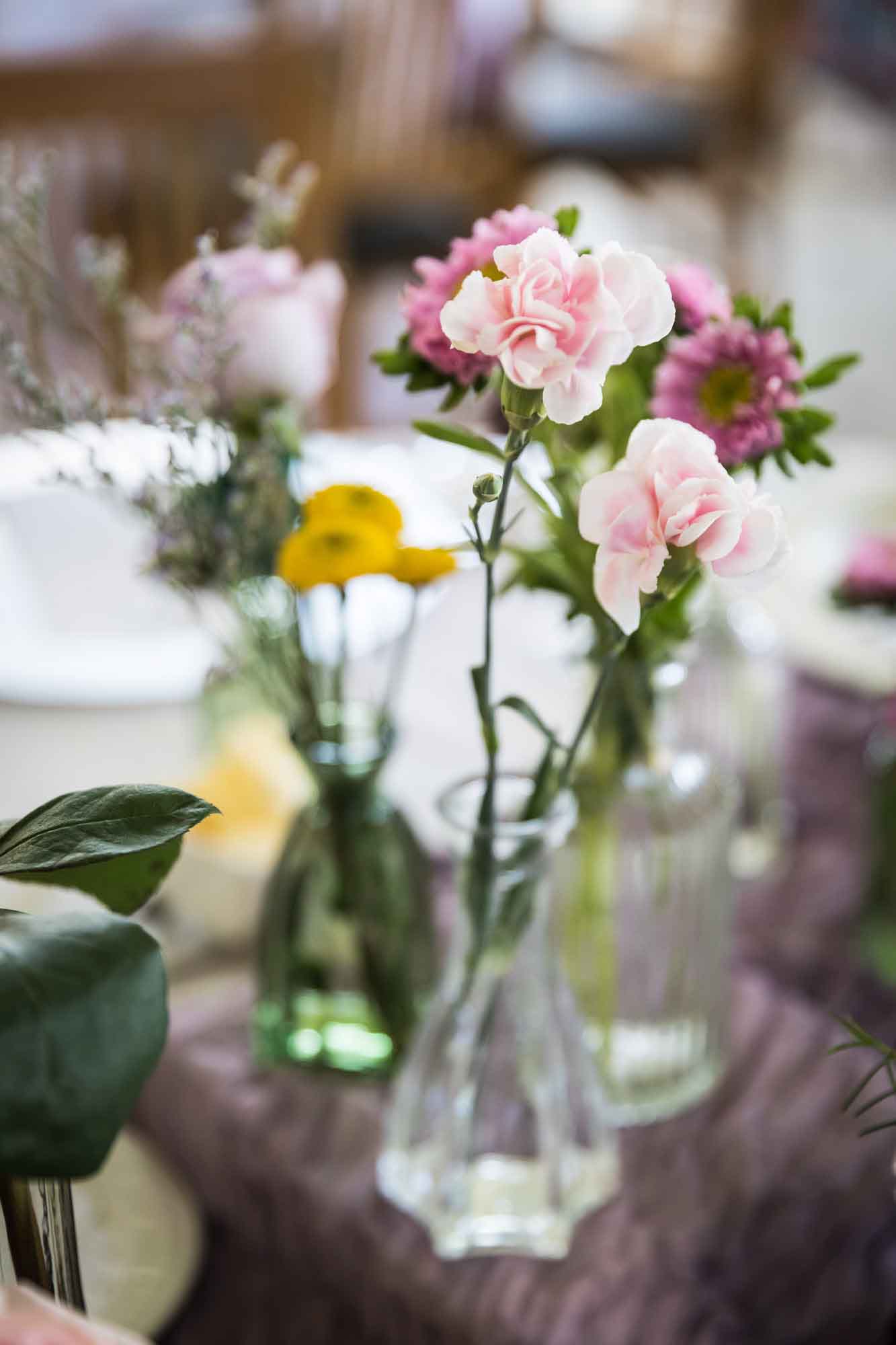 Centerpieces comprised of several vases with different colorful flowers during a Guenther House wedding reception