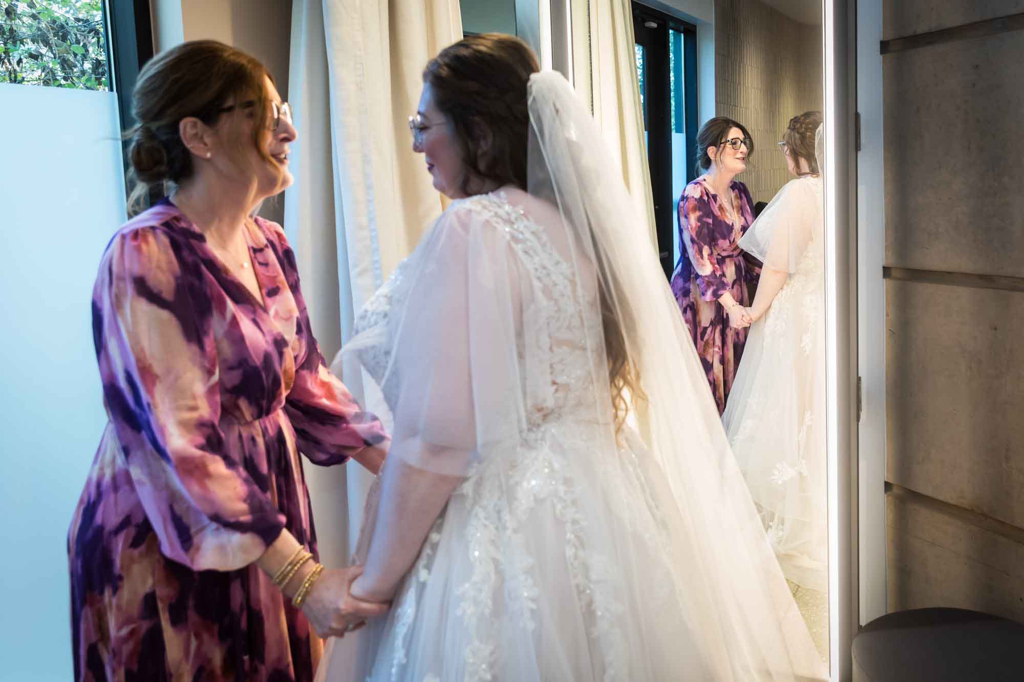 Mother holding hands with bride in front of mirror before a San Antonio Botanical Garden wedding ceremony