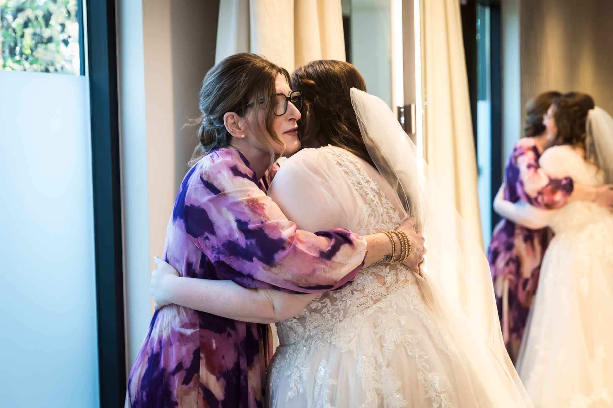 Bride and mother hugging in front of mirror before a San Antonio Botanical Garden wedding ceremony
