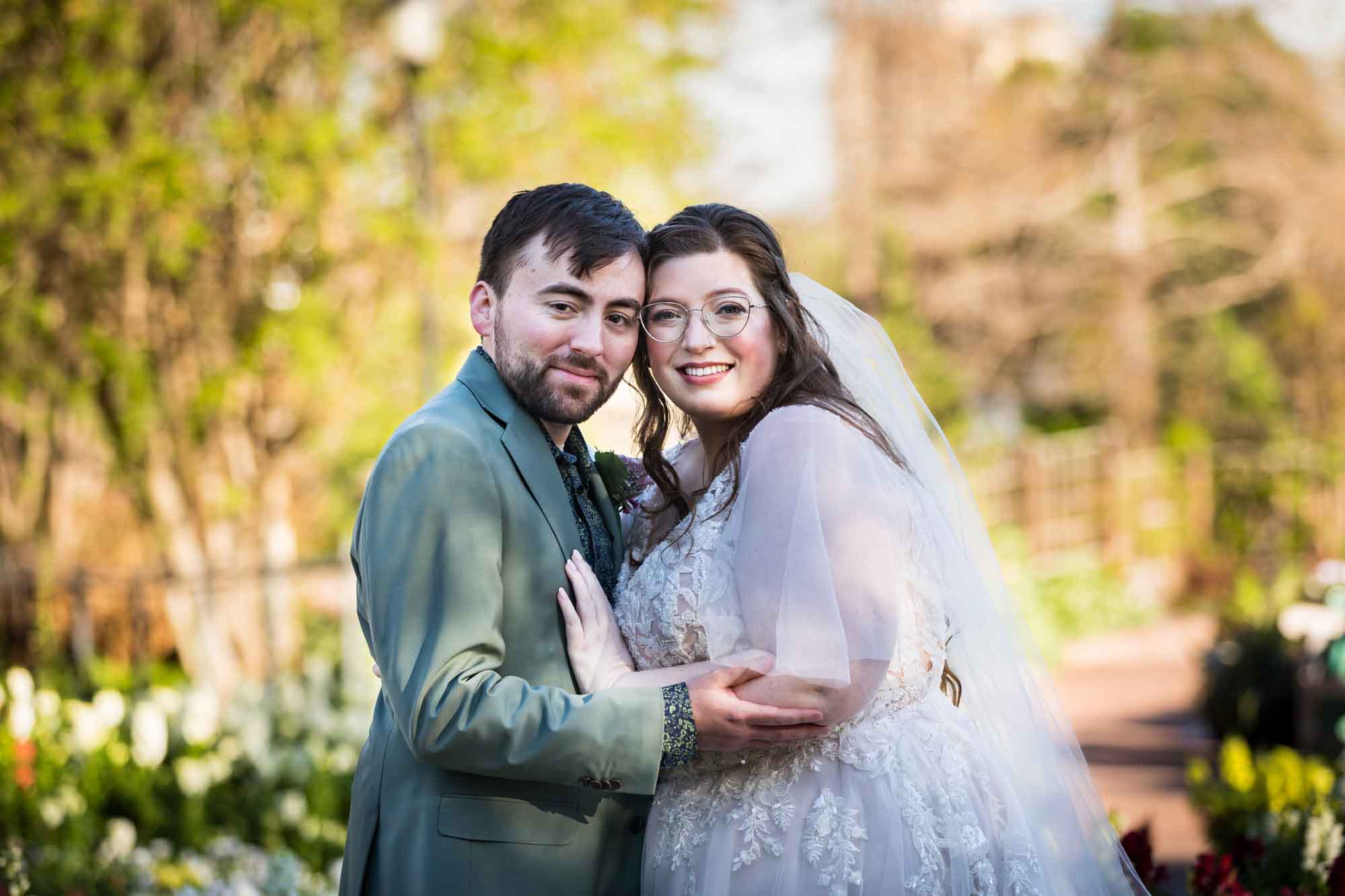 Bride and groom hugging in front of trees before a San Antonio Botanical Garden wedding ceremony