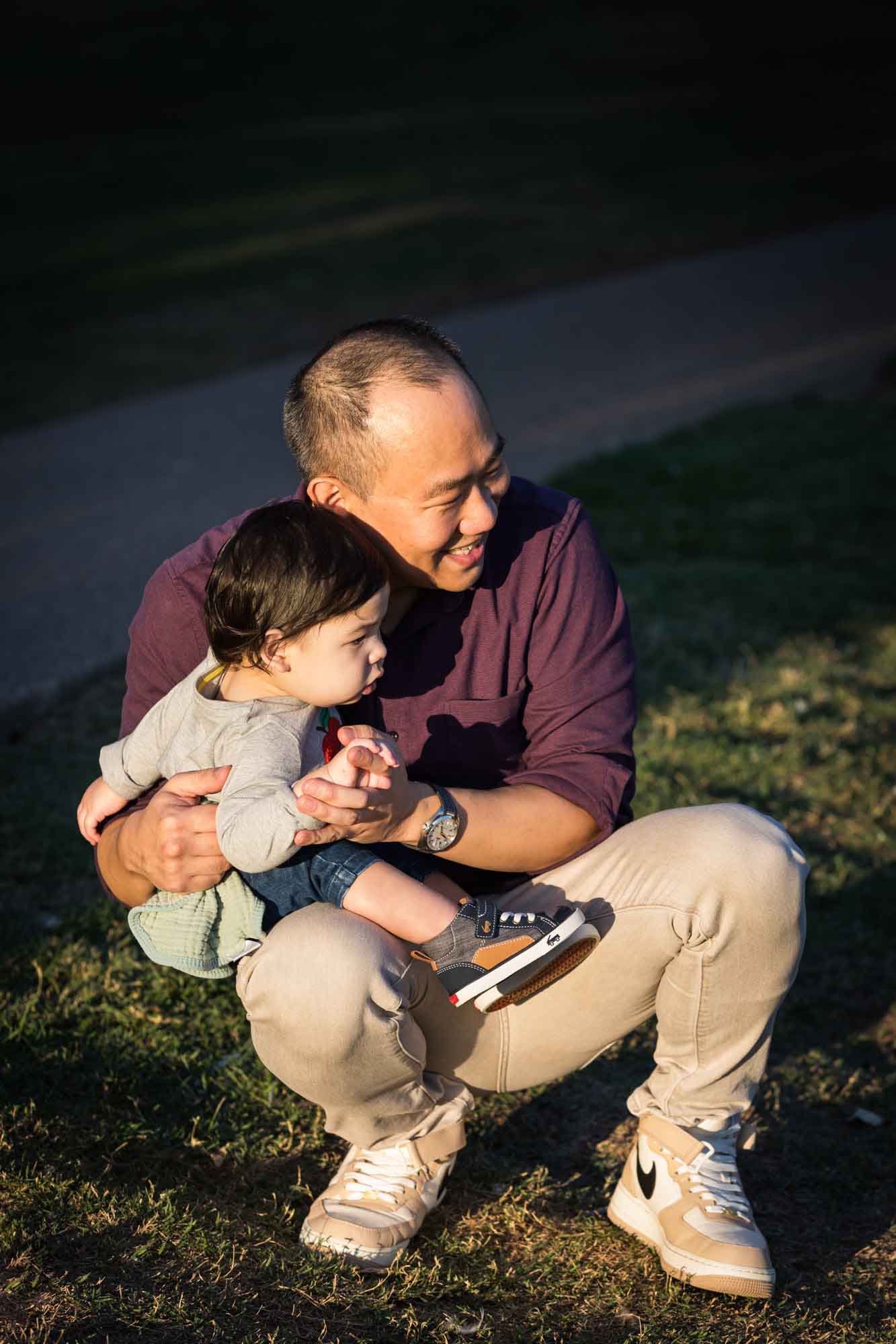 Little boy being held by father wearing purple shirt during a Mueller Lake Park family portrait