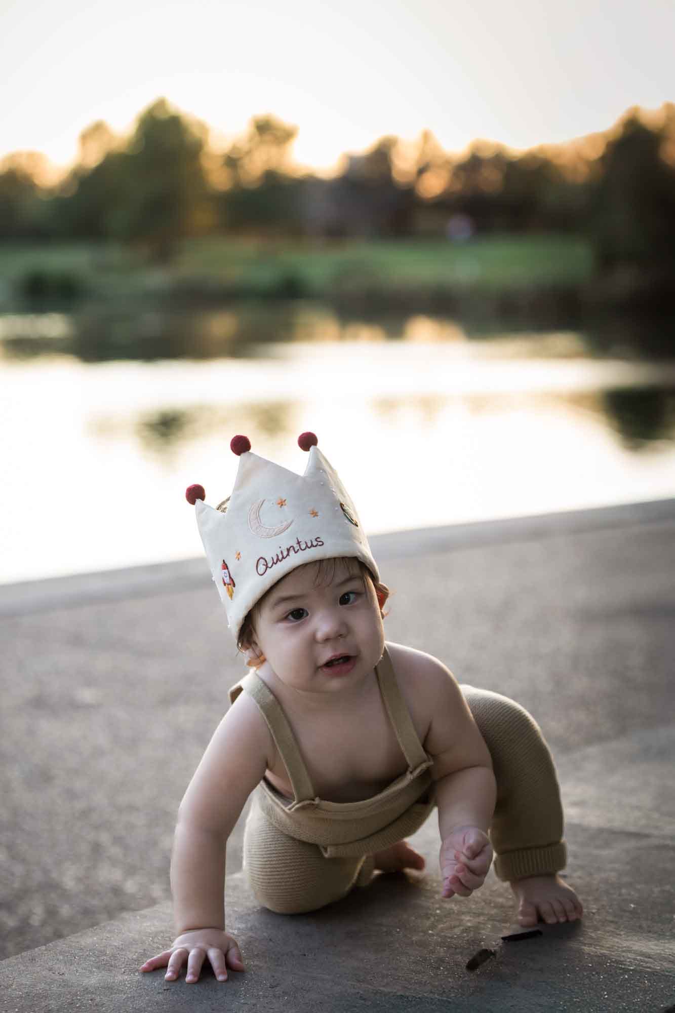 Little boy wearing a cloth crown beside Mueller Lake at sunset during a Mueller Lake Park family portrait