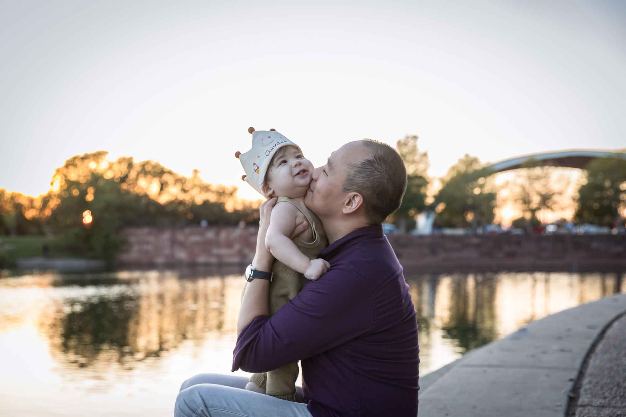 Father and little boy playing on concrete ground beside Mueller Lake during a Mueller Lake Park family portrait
