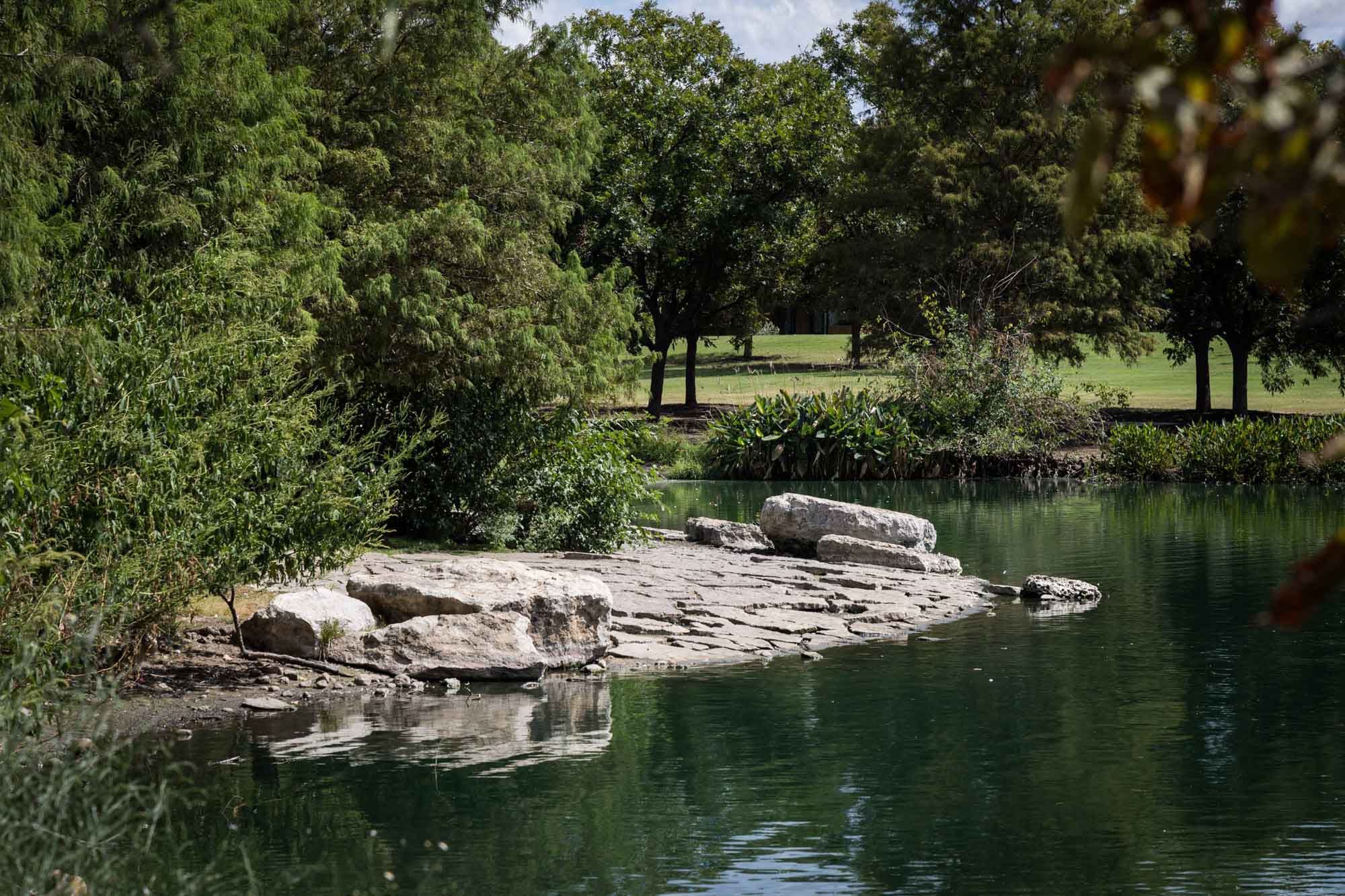 Lake surrounded by trees and rocks at Mueller Lake Park