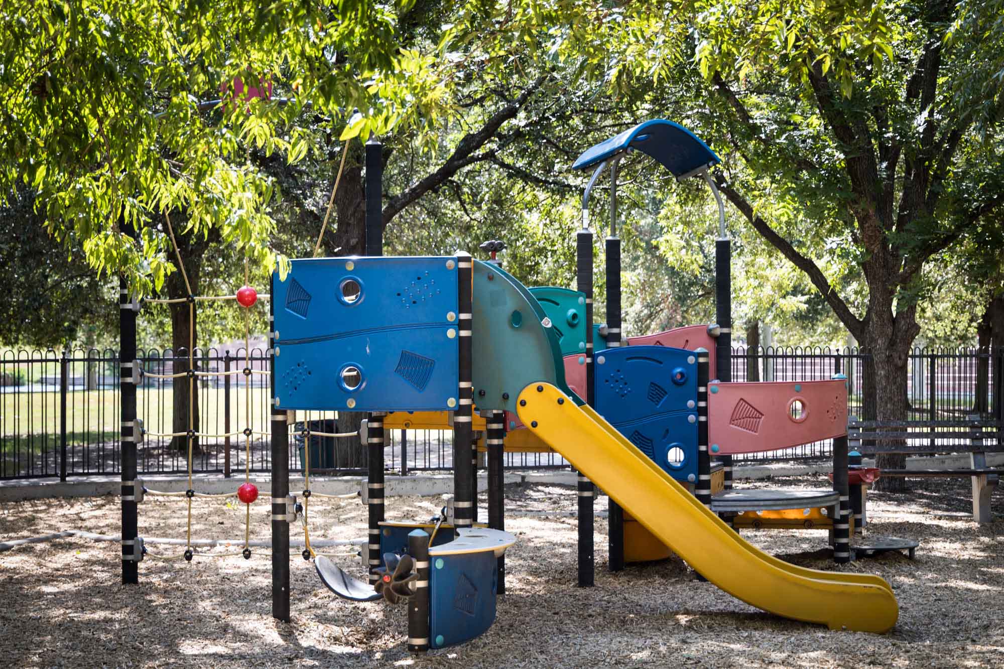 Colorful playground under trees at Mueller Lake Park