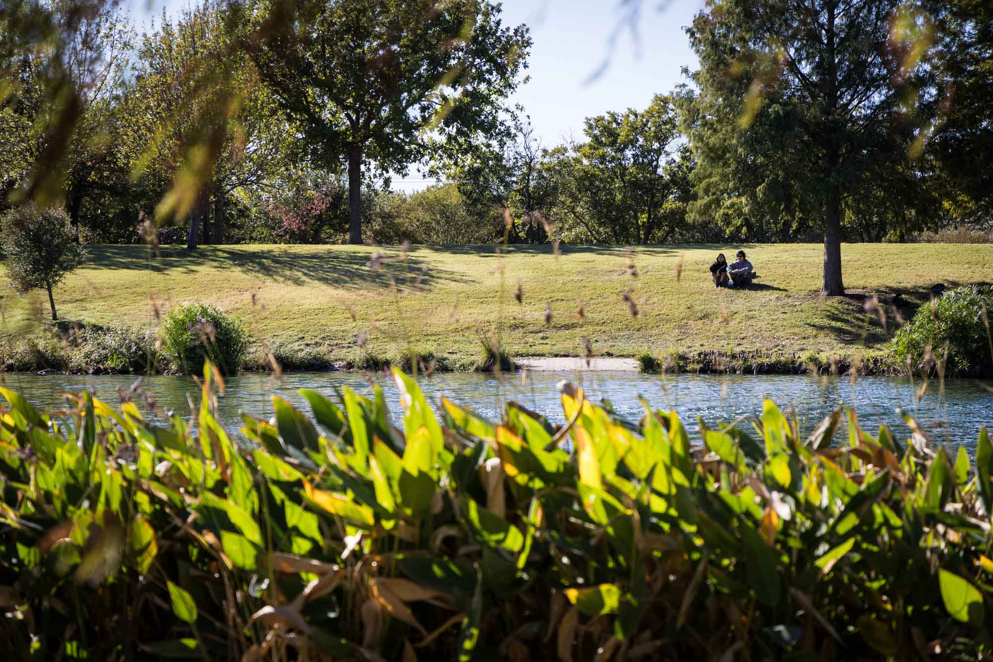 Two people sitting beside lake at Mueller Lake Park