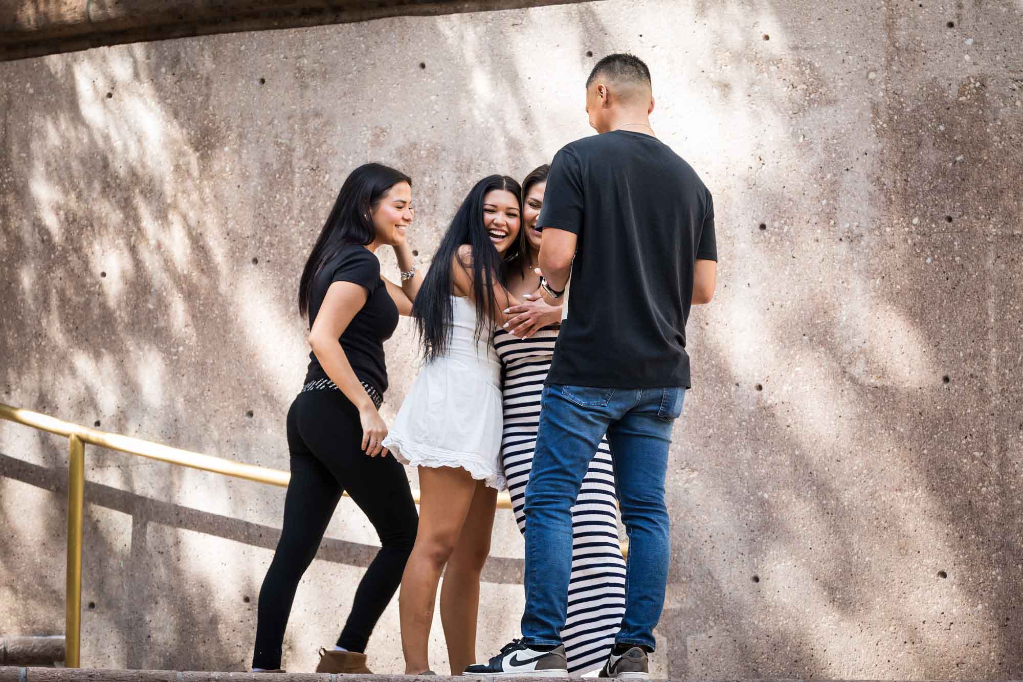 Woman, man, and two daughters hugging after Riverwalk surprise proposal in San Antonio