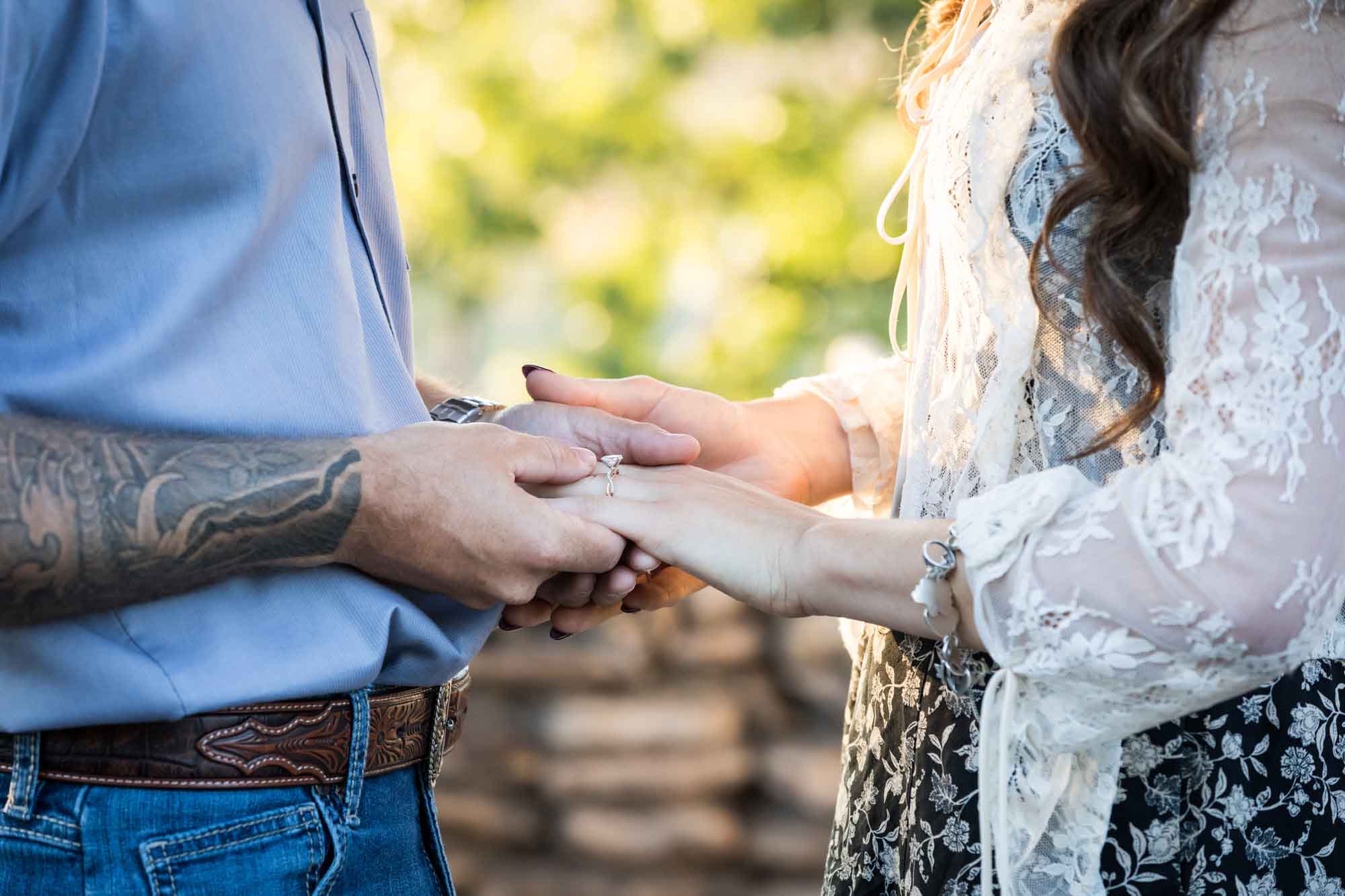 Close up of couple holding hands showing woman wearing engagement ring during a Japanese Tea Garden engagement portrait 
