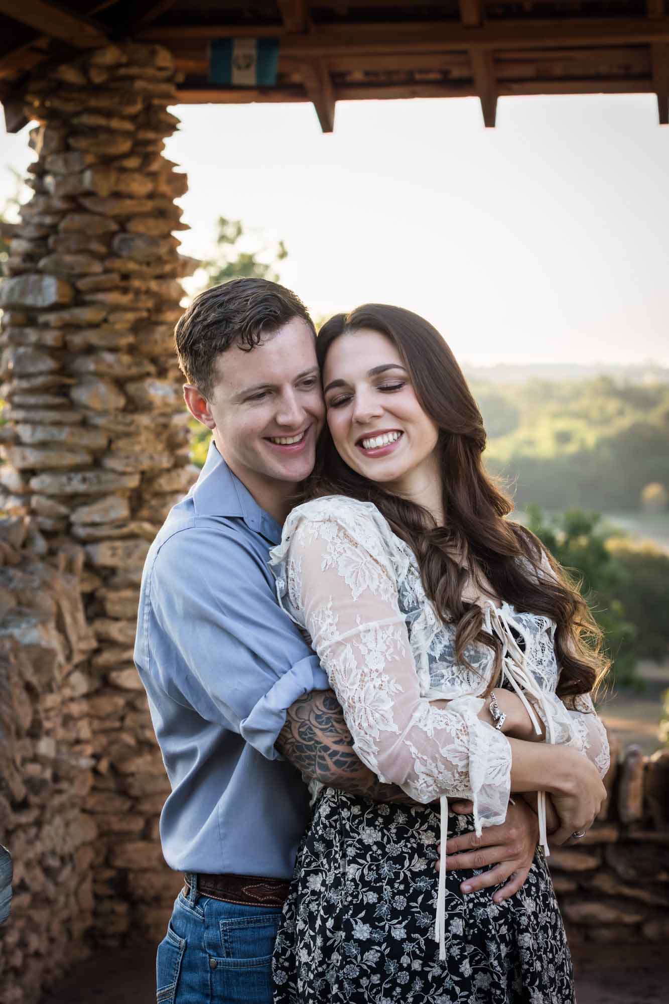 Couple hugging in front of stone building during a Japanese Tea Garden engagement portrait 