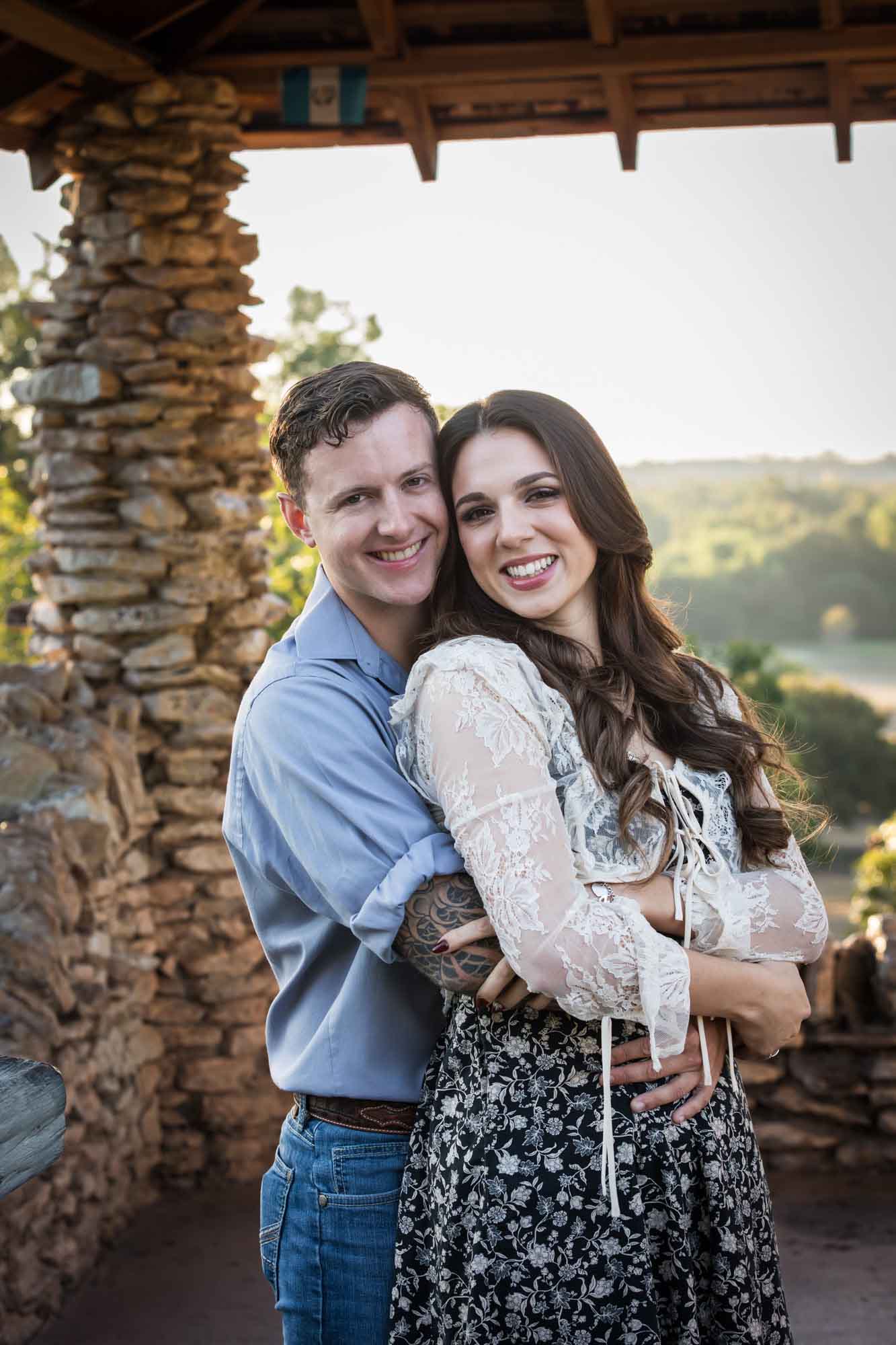 Couple hugging in front of stone building during a Japanese Tea Garden engagement portrait 